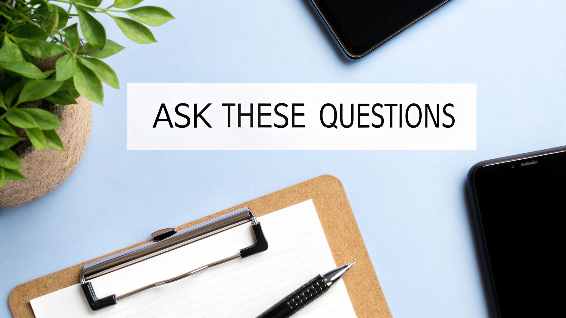 A light blue desk with a plant, two phones, a clipboard, and a pen, with text 'ASK THESE QUESTIONS'.