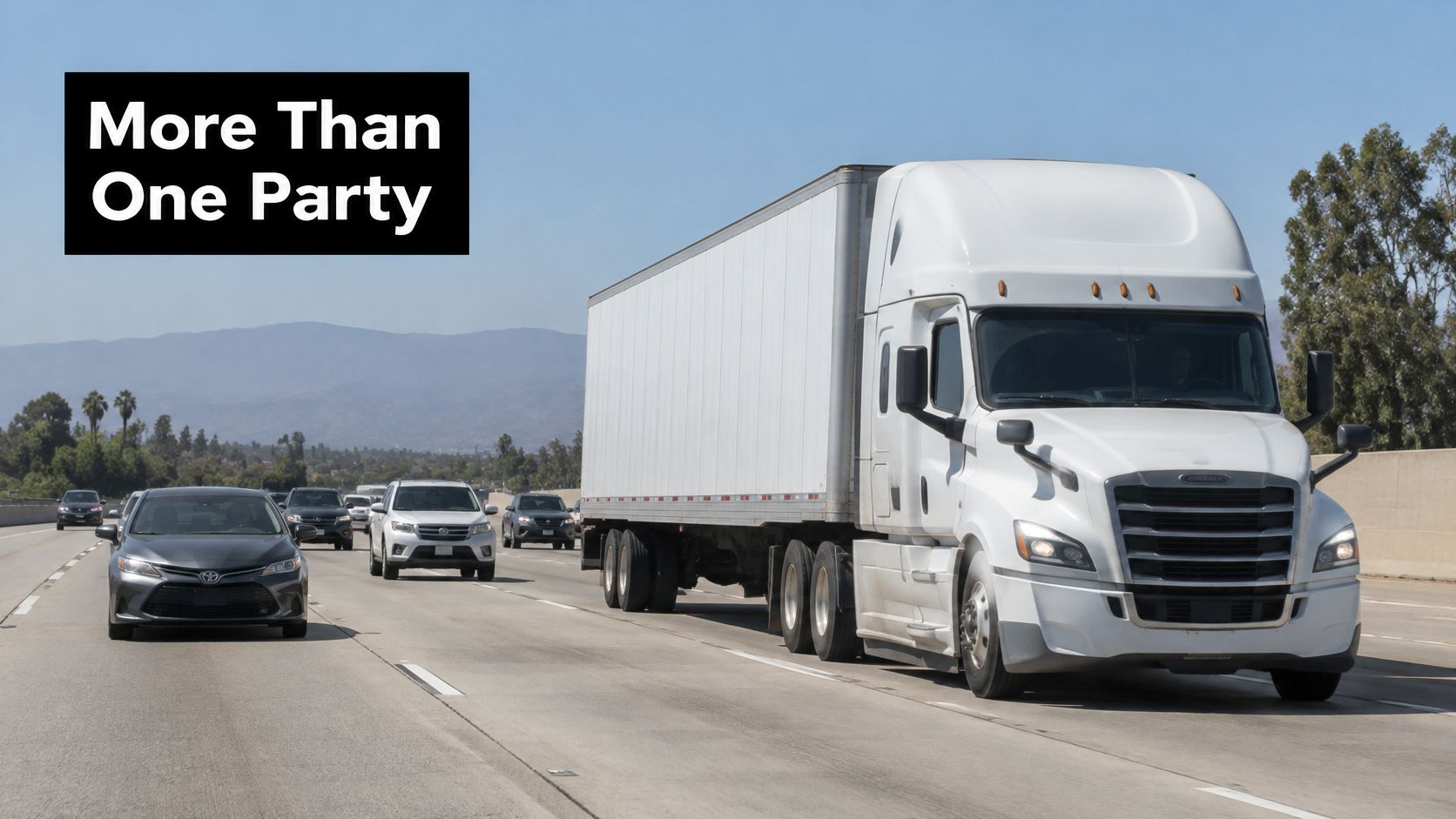 A white semi-truck driving on a busy highway next to multiple passenger cars under a clear sky.