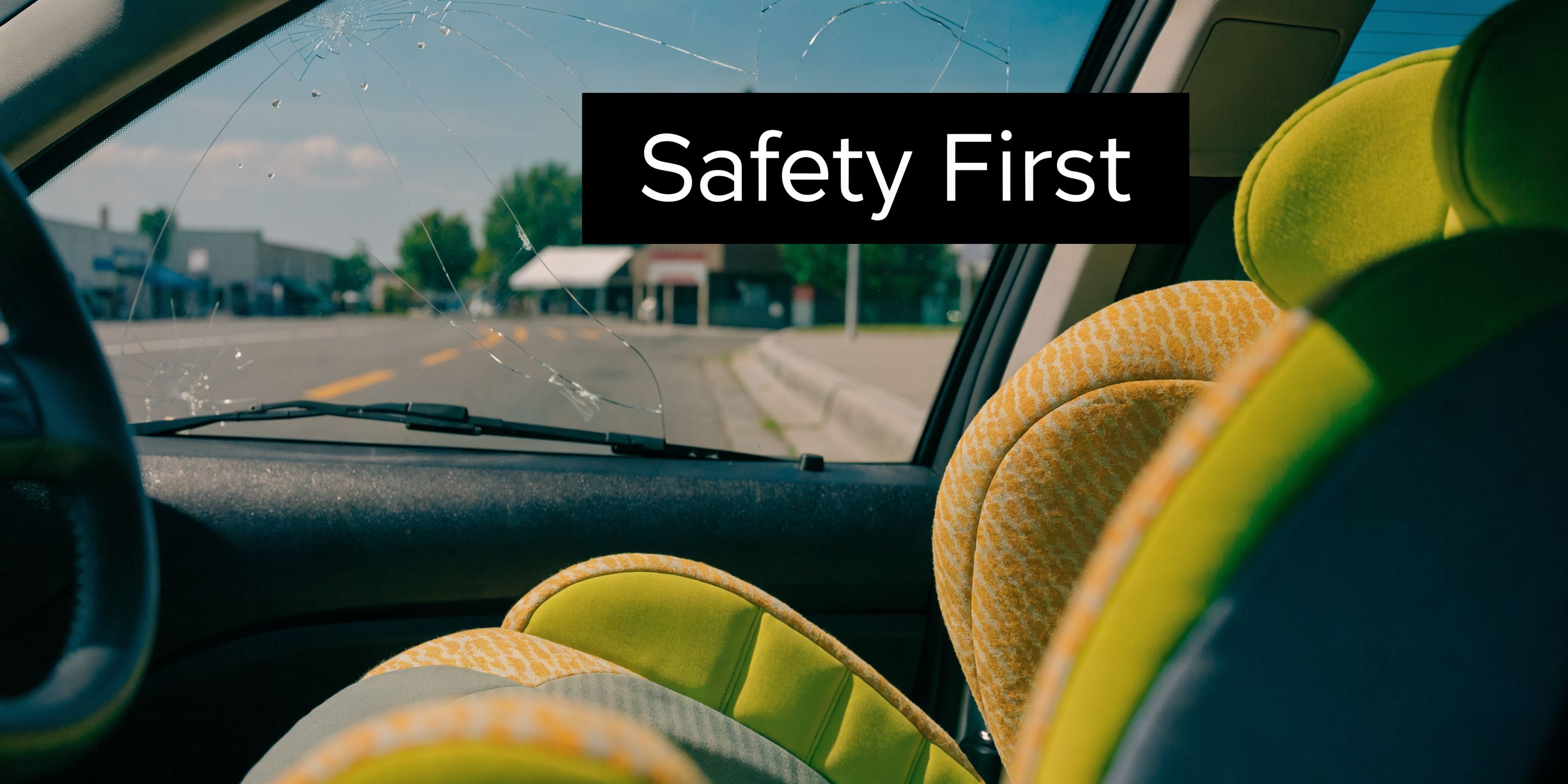 A car windshield with major damage parked next to a colorful child seat emphasizing safety awareness.