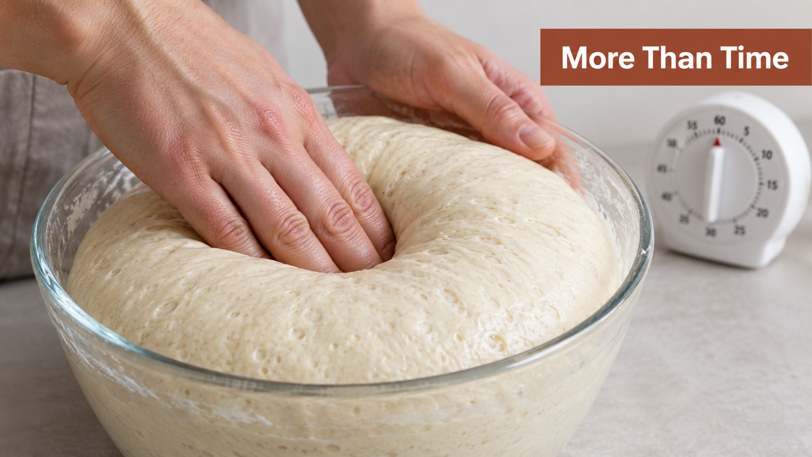 A pair of hands gently pressing down into a large bowl of rising bread dough.