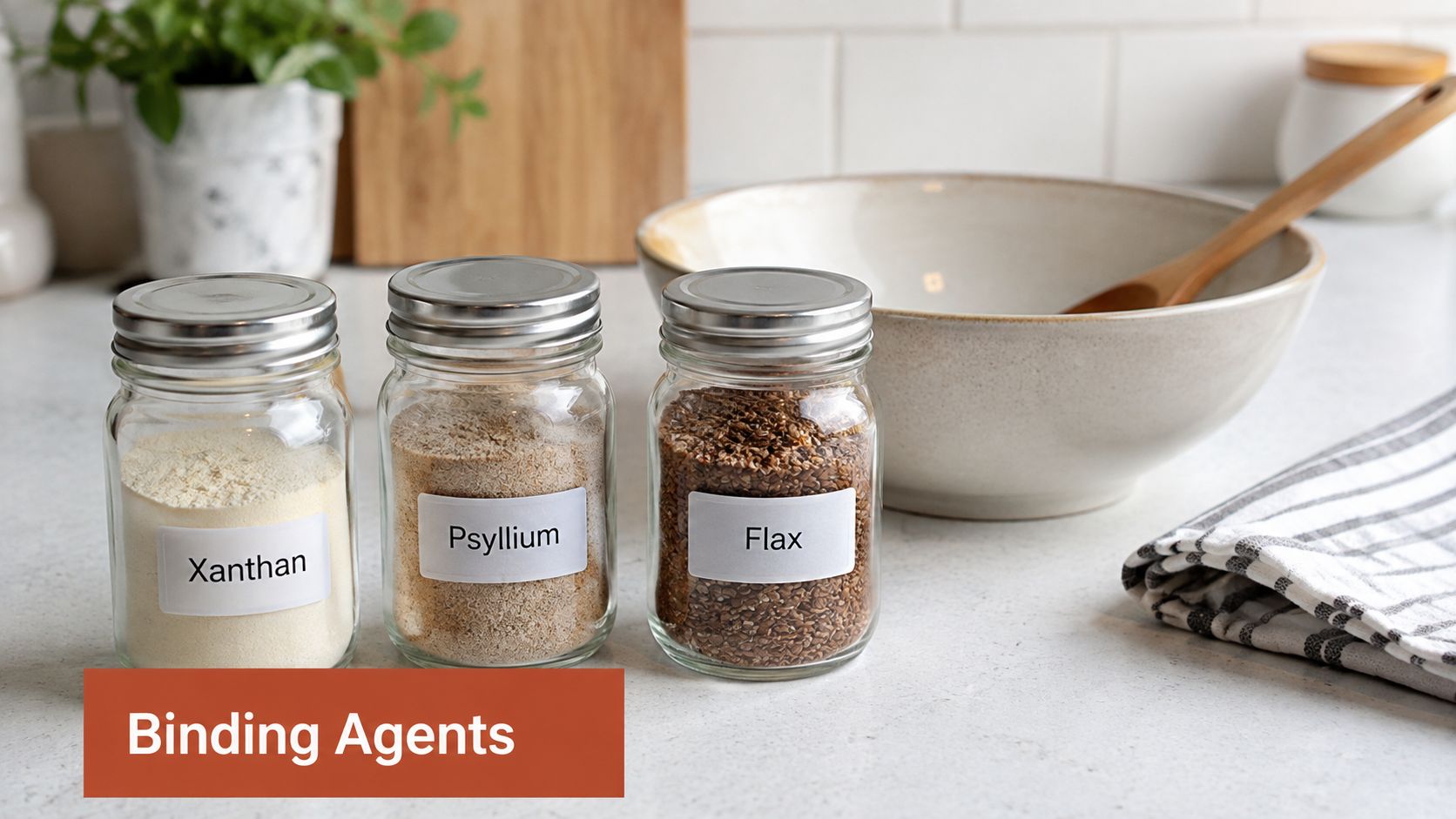 Three glass jars containing xanthan gum, psyllium husk, and flax seeds on a kitchen counter for baking.