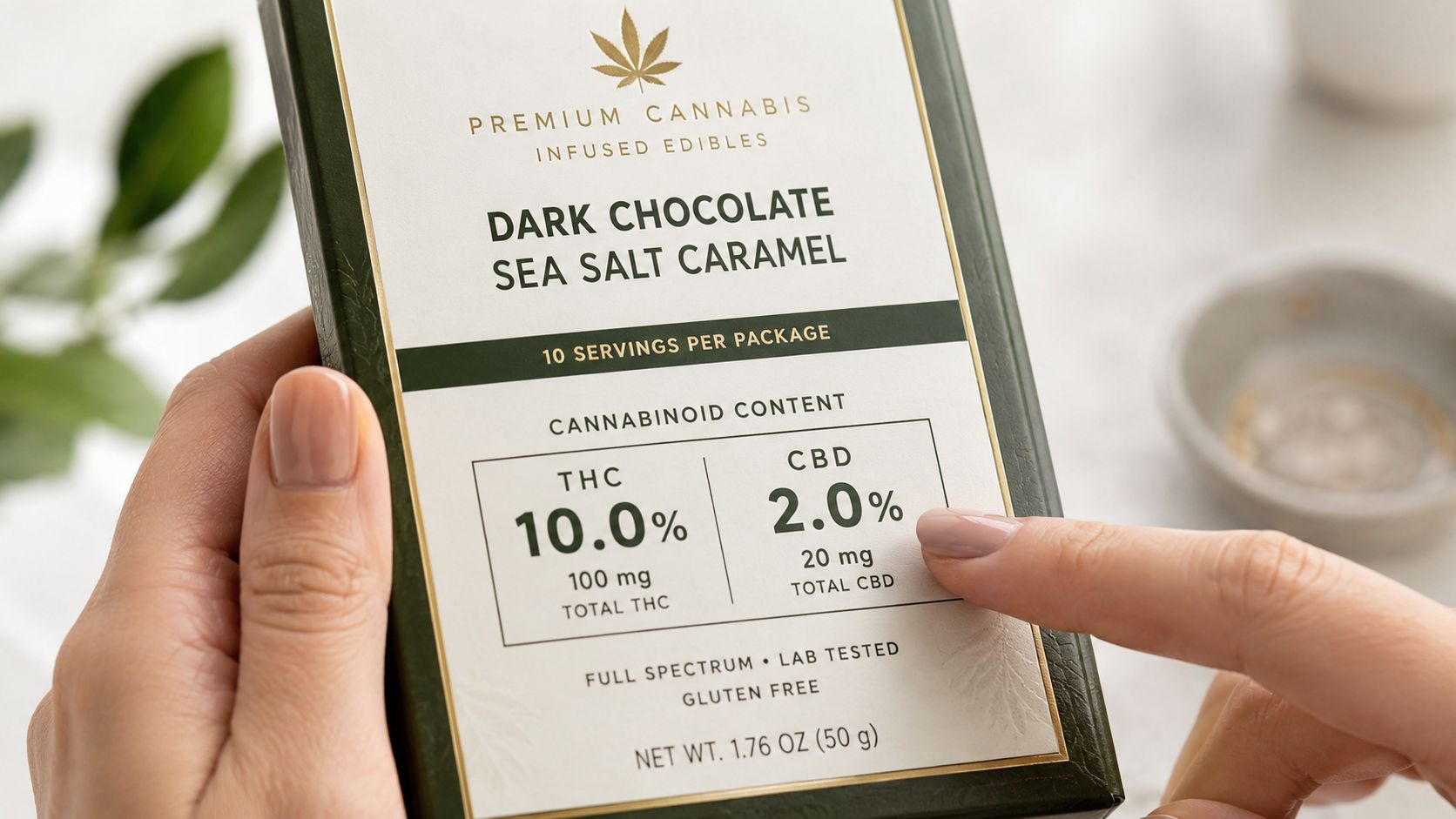 A person holding a premium dark chocolate sea salt caramel cannabis edible package with CBD and THC content.