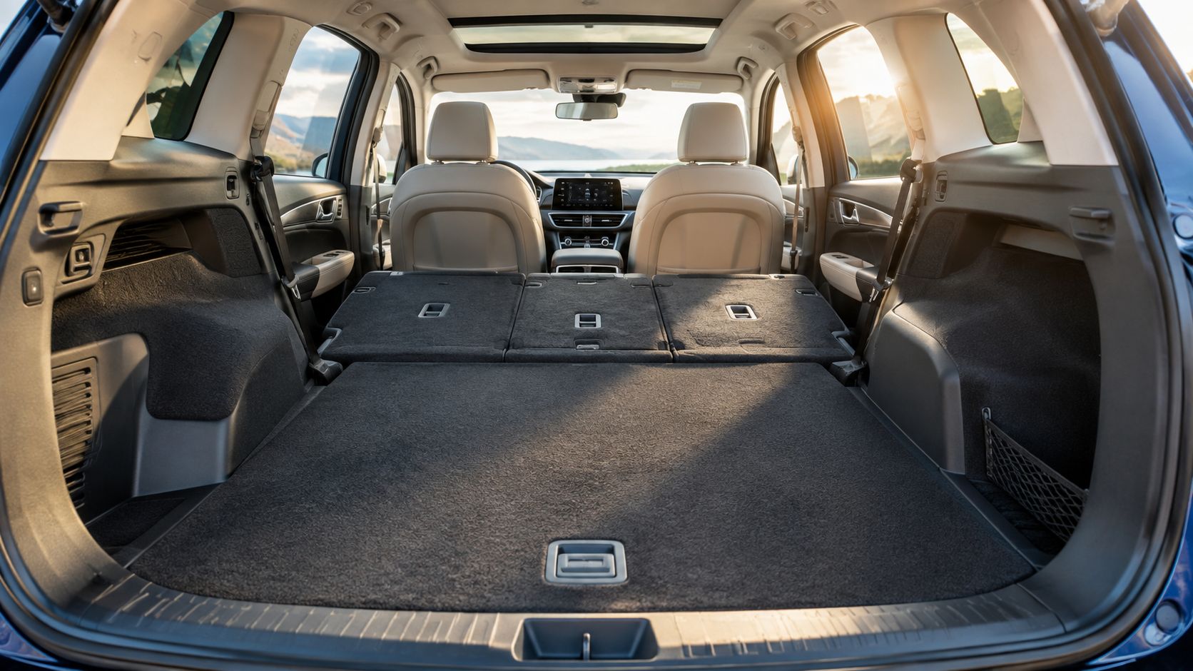 Rear interior view of a spacious SUV cargo area with folded seats and a panoramic sunroof.