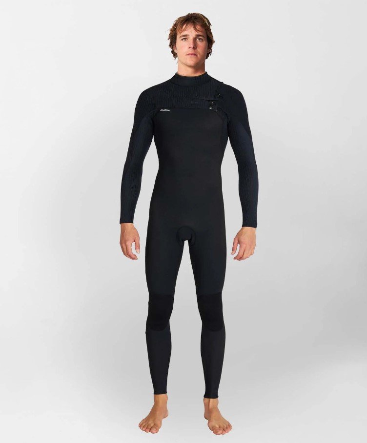 A man models a black, full-body wetsuit with textured shoulders and a chest zip.