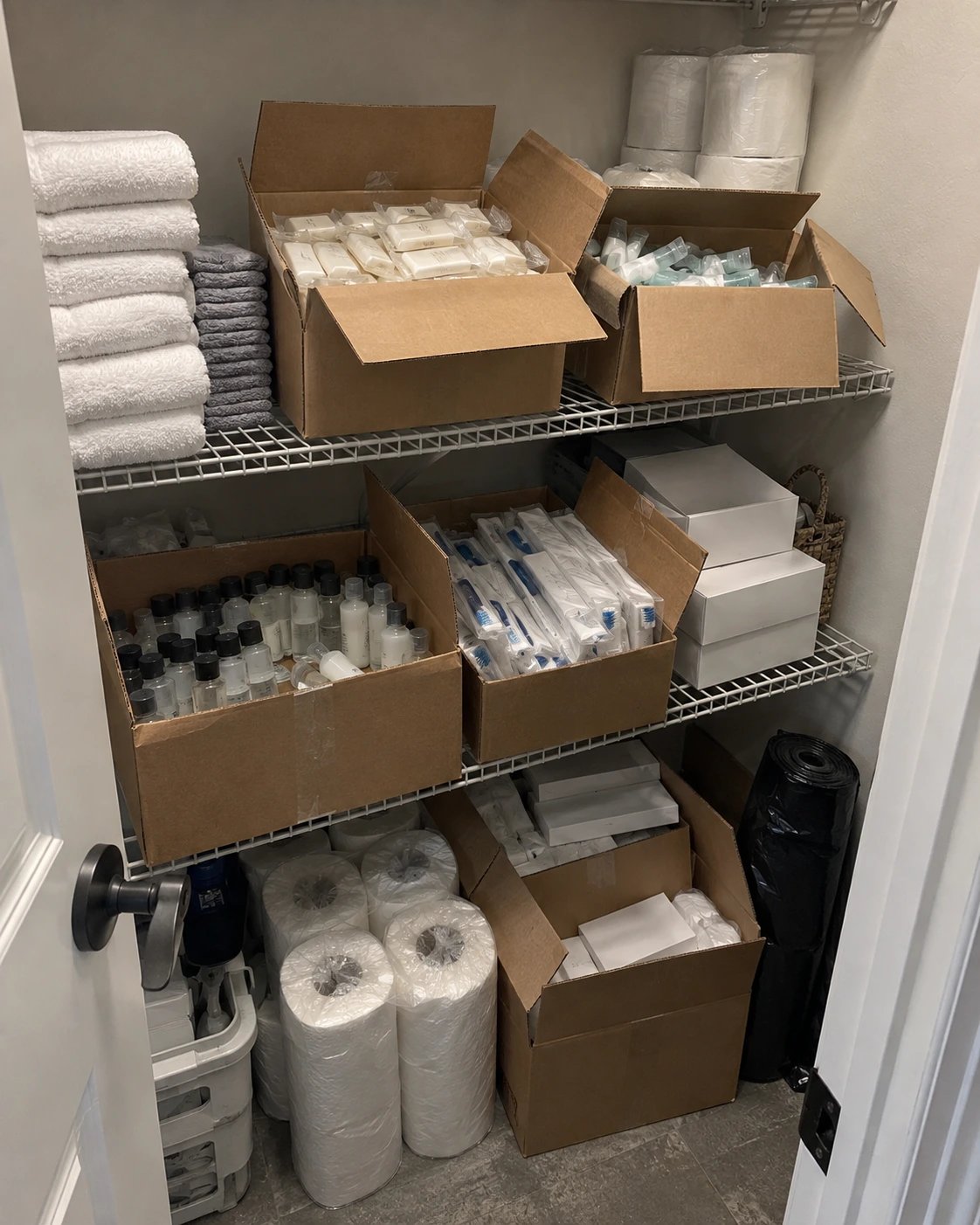 A well-stocked supply closet with neatly organized towels, toiletries, and cleaning essentials for an Airbnb.