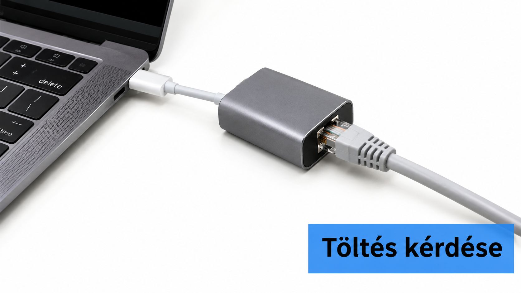 Egy ezüst színű USB-C Ethernet hálózati átalakító, amely egy laptophoz csatlakozik egy fehér háttér előtt.