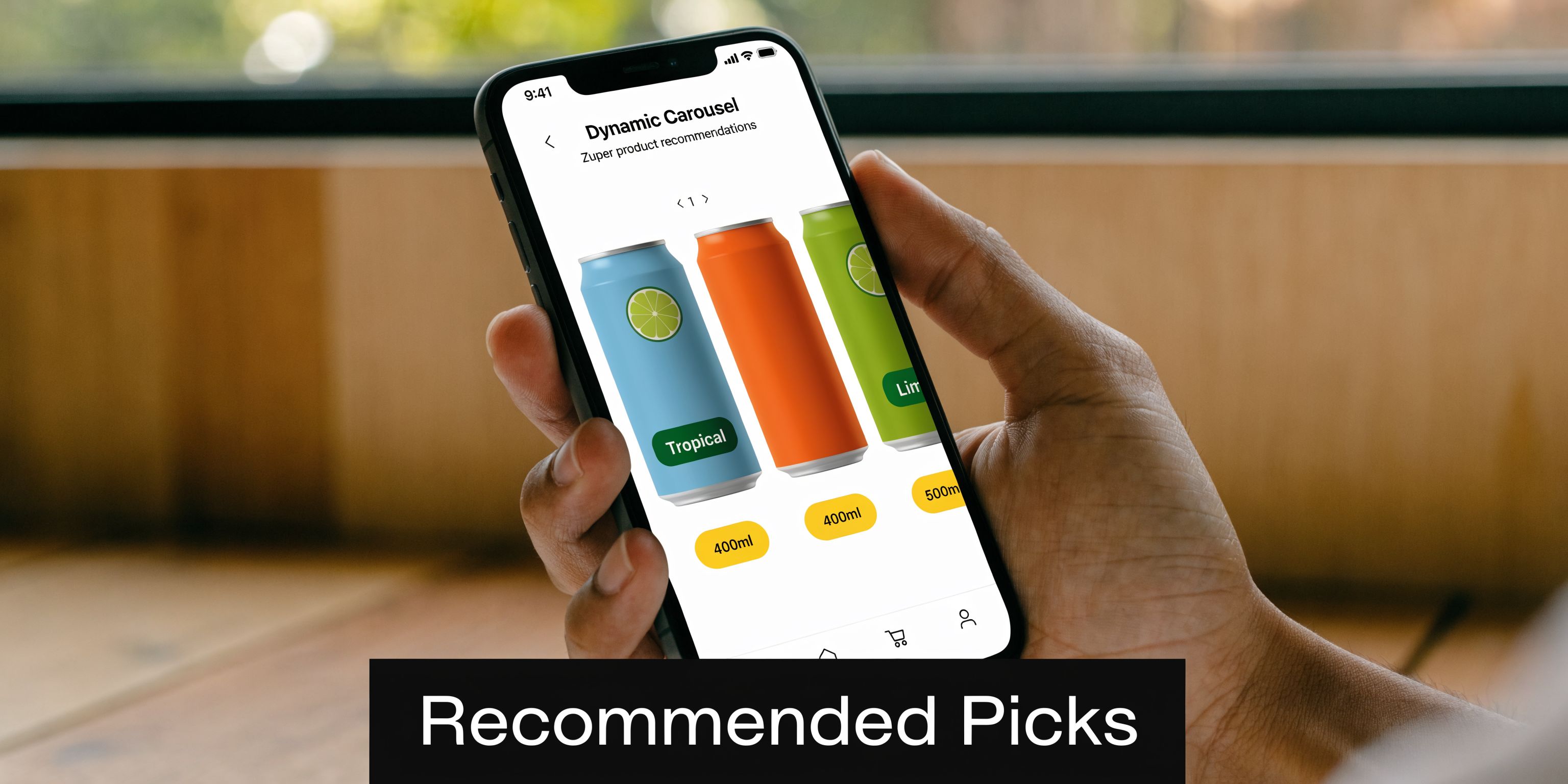 A hand holds a smartphone displaying a shopping application with a dynamic product carousel for beverages.