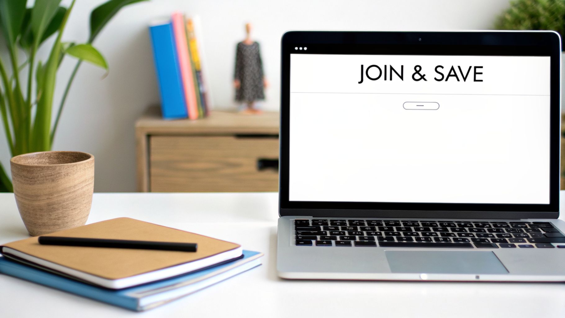 Modern workspace with a laptop showing 'JOIN & SAVE' message, notebooks, and a plant.