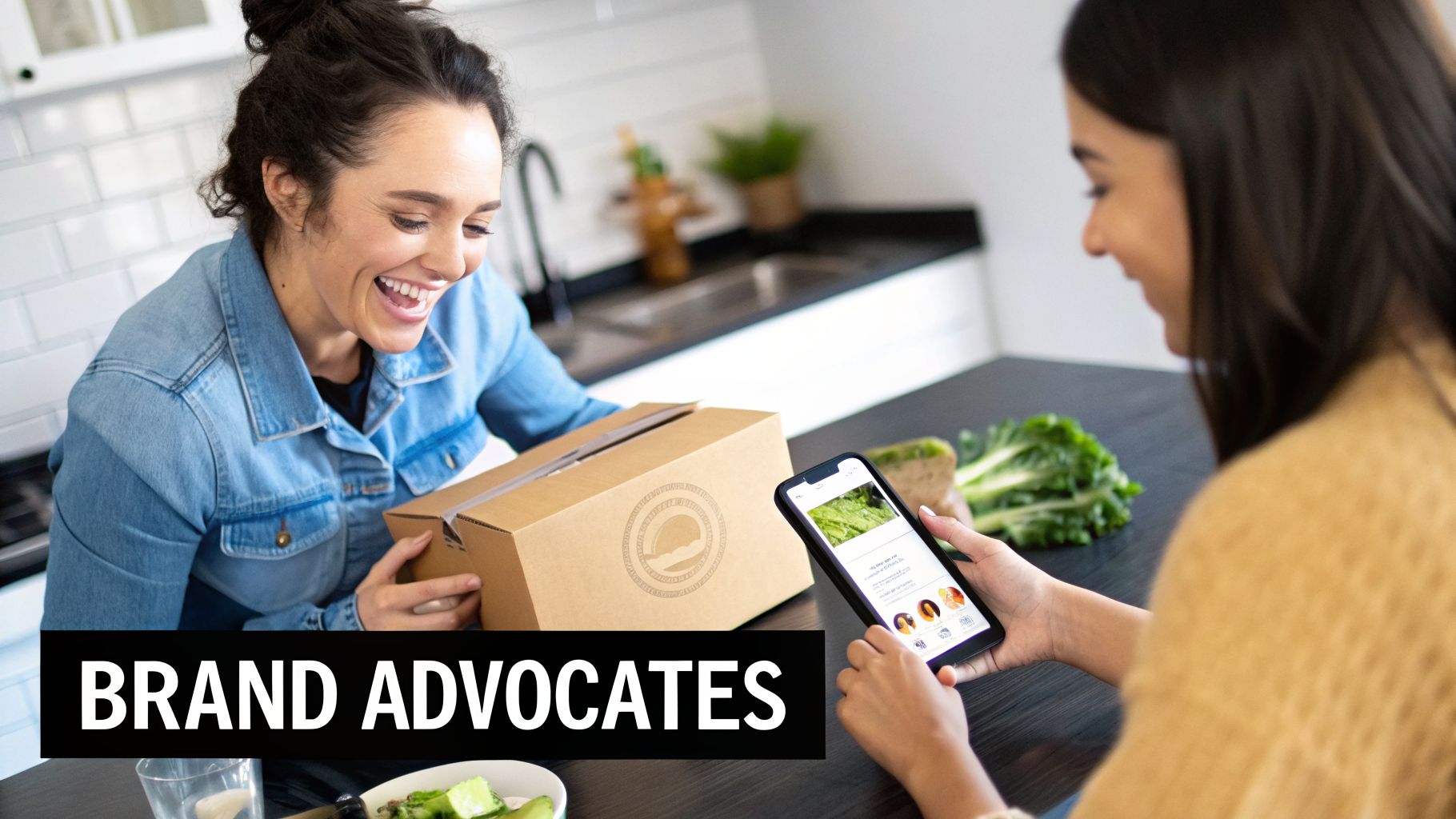 Two happy women in a kitchen, one smiling while holding a meal kit box, the other using a food app.