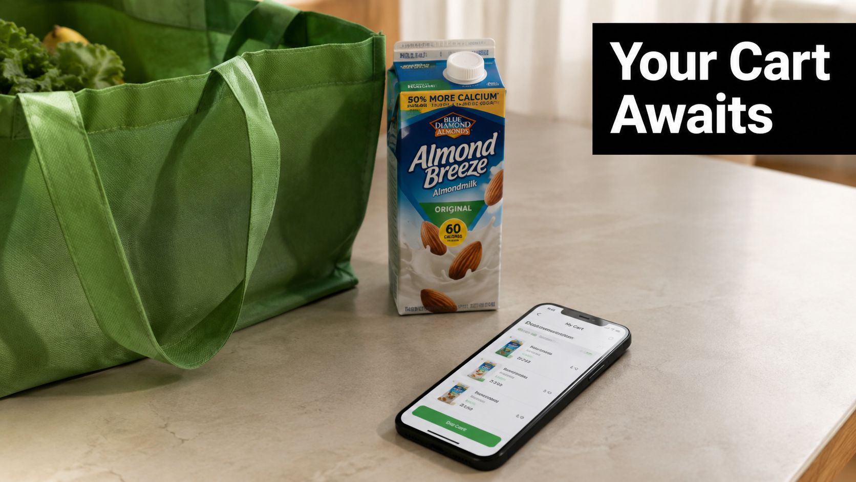 A green reusable grocery bag and a carton of almond milk beside a smartphone showing a shopping cart.