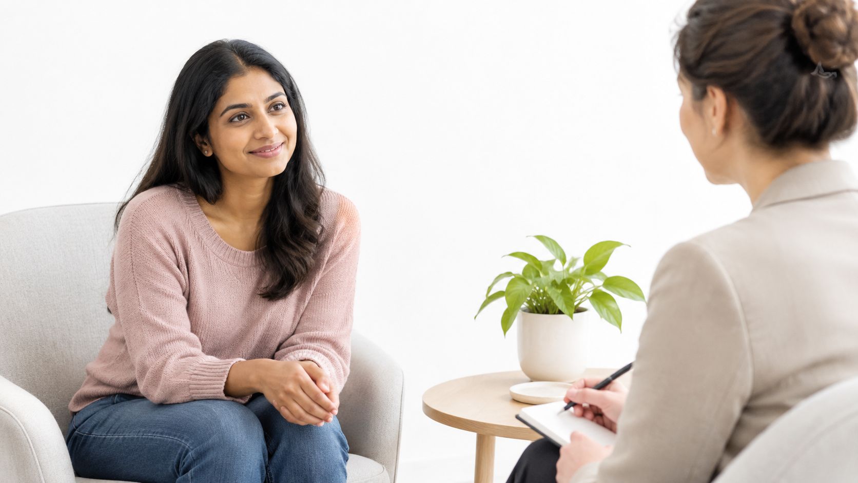 A woman smiles while talking to her therapist during a professional mental health counseling session in office.