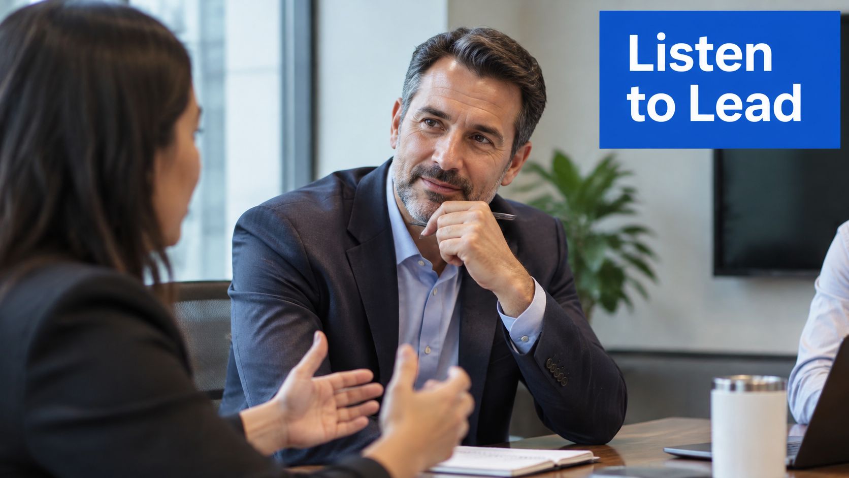 A professional man and woman having a focused business discussion in a modern office meeting room.
