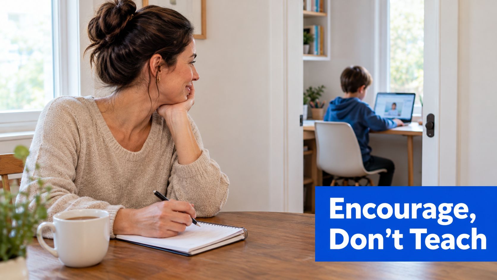 A mother sitting at a table with a notebook while looking at her son studying online.