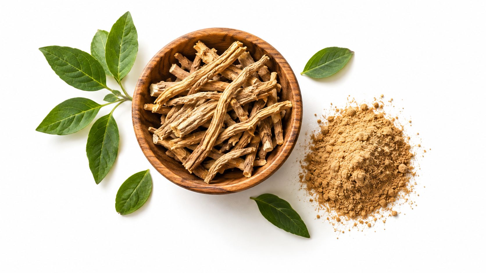 A wooden bowl filled with ashwagandha roots, surrounded by fresh green leaves and a pile of herbal powder.