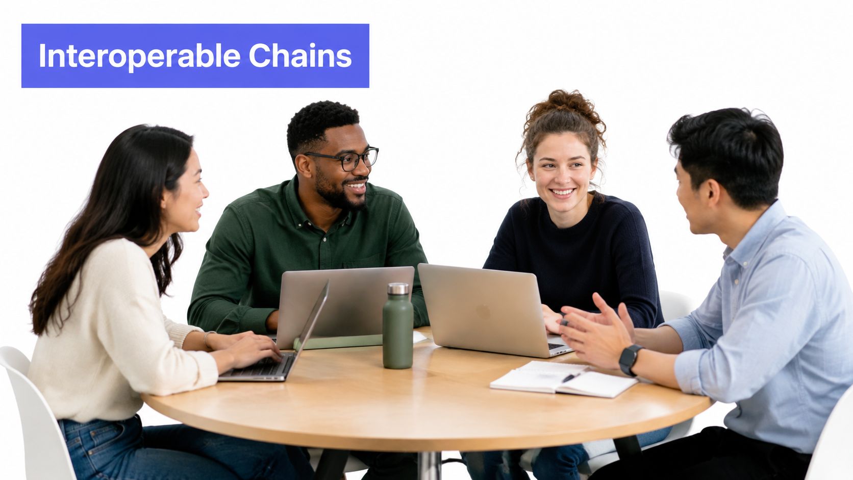 A diverse group of four professionals collaborating and discussing work around a circular wooden office table.