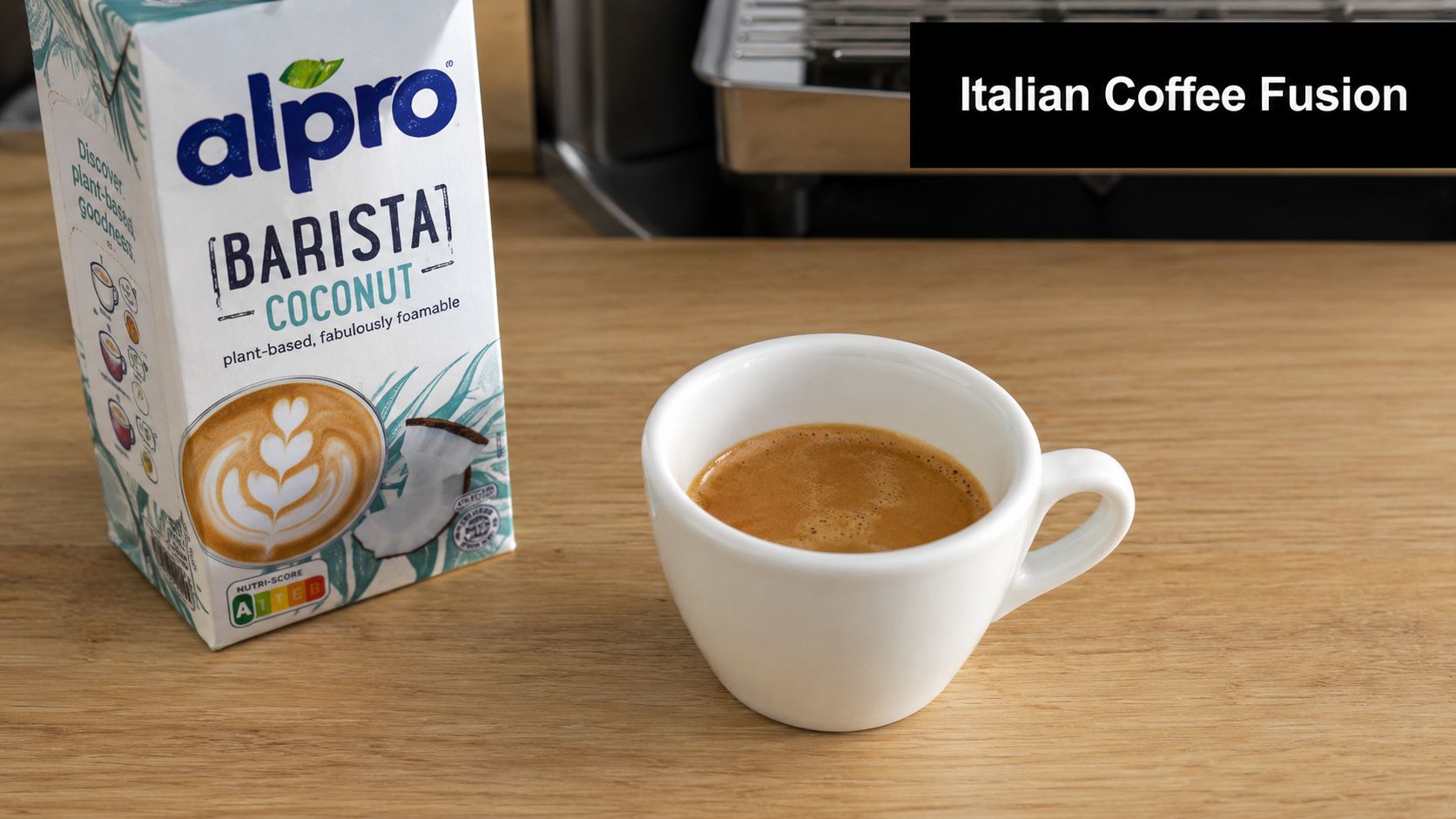 A carton of Alpro Barista Coconut milk next to a white ceramic cup filled with espresso.