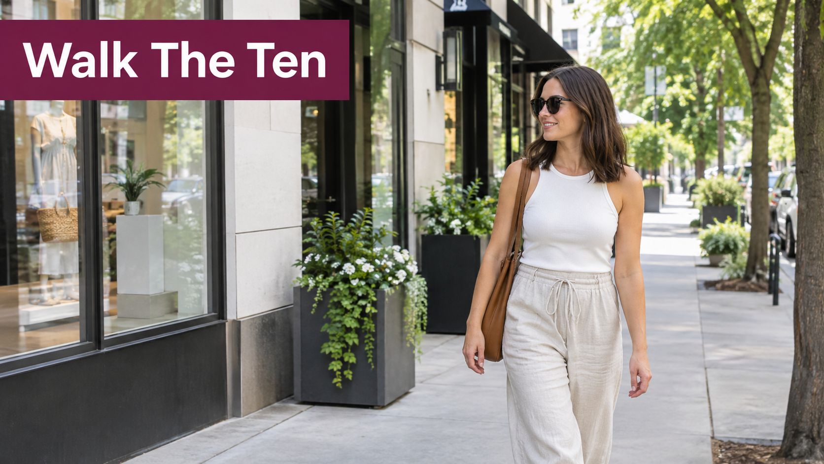A woman walks down a city sidewalk past luxury storefronts, enjoying a sunny day of shopping.