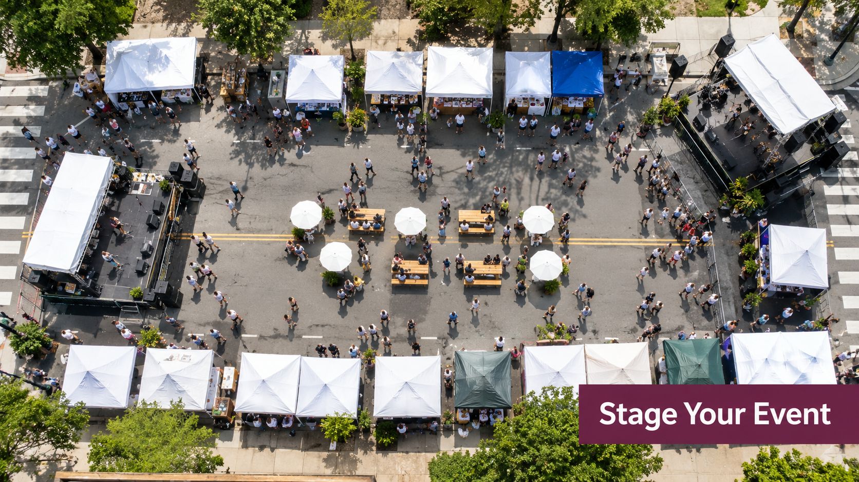 An aerial view of a vibrant outdoor downtown street festival with vendor tents, stages, and crowds.