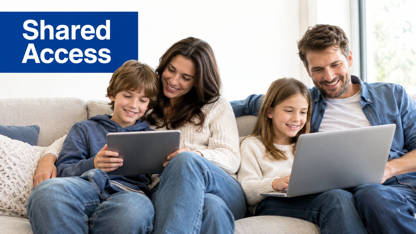 A happy family sitting on a couch together, using a tablet and a laptop to access digital content.