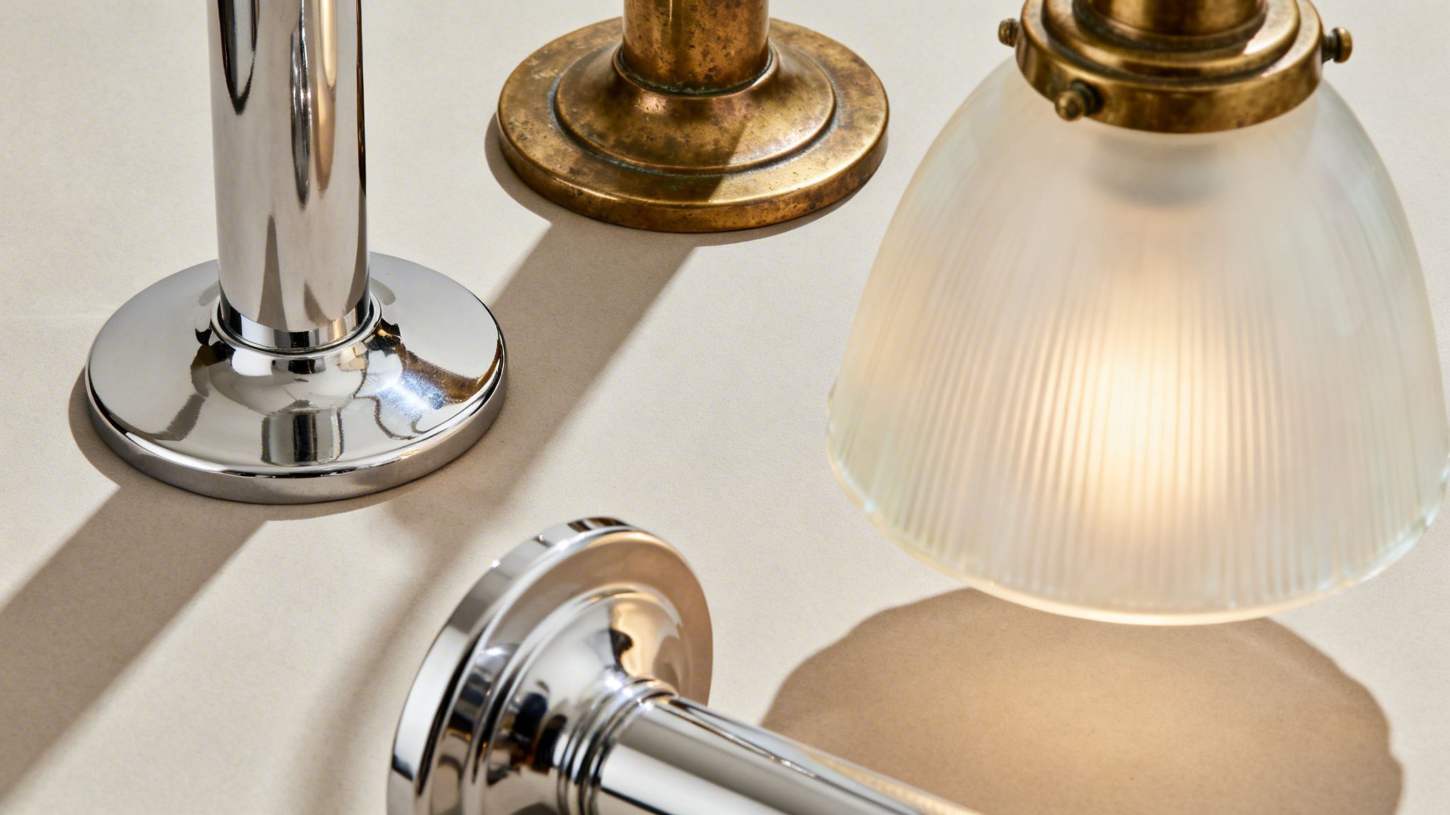 Art Deco lamp parts, featuring shiny chrome, aged brass, and a glowing ribbed glass shade.