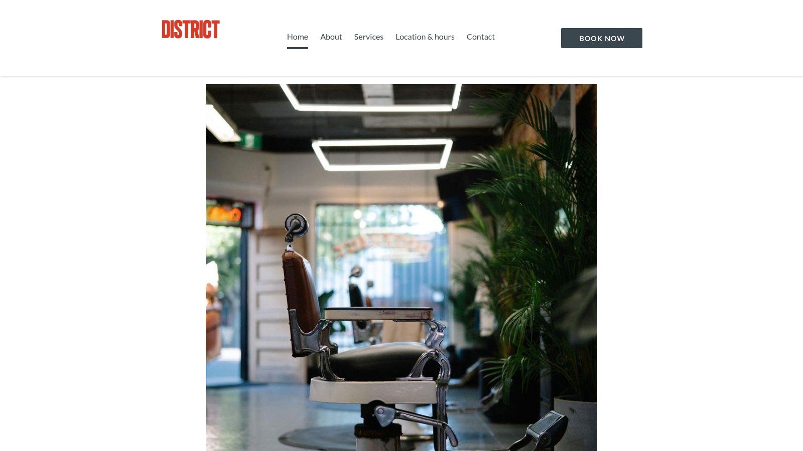 District Barbershop's modern, minimalist interior with barber chairs and stations.