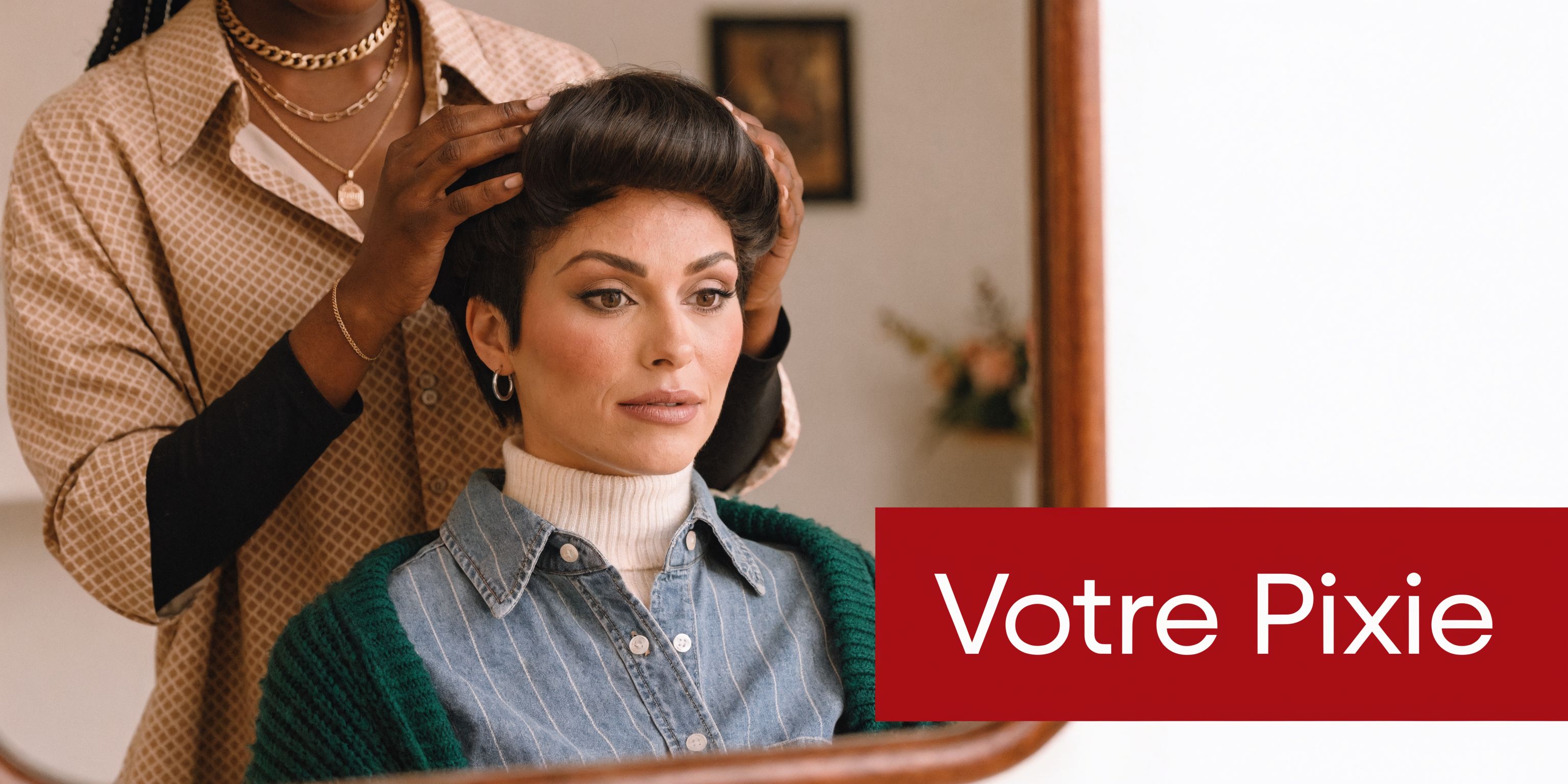Une coiffeuse ajuste une perruque coupe pixie élégante sur les cheveux d'une femme devant un miroir.