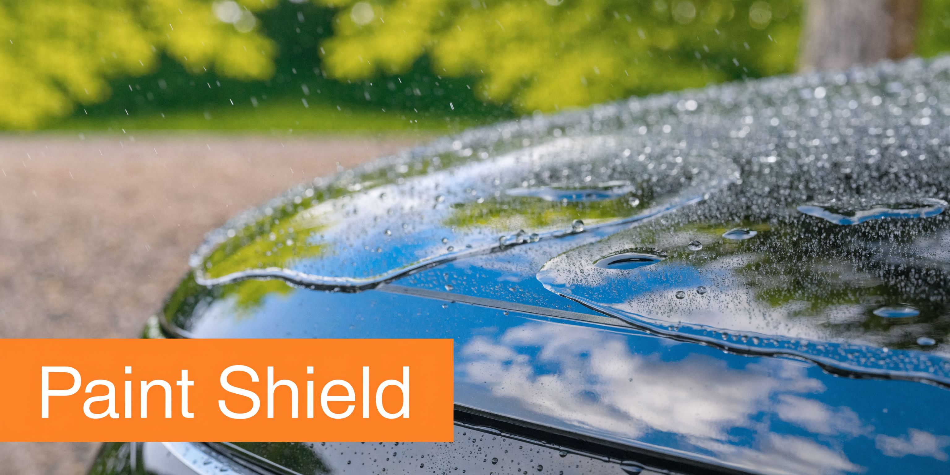 A close-up view of a car hood with a hydrophobic graphene coating repelling rainwater during a shower.