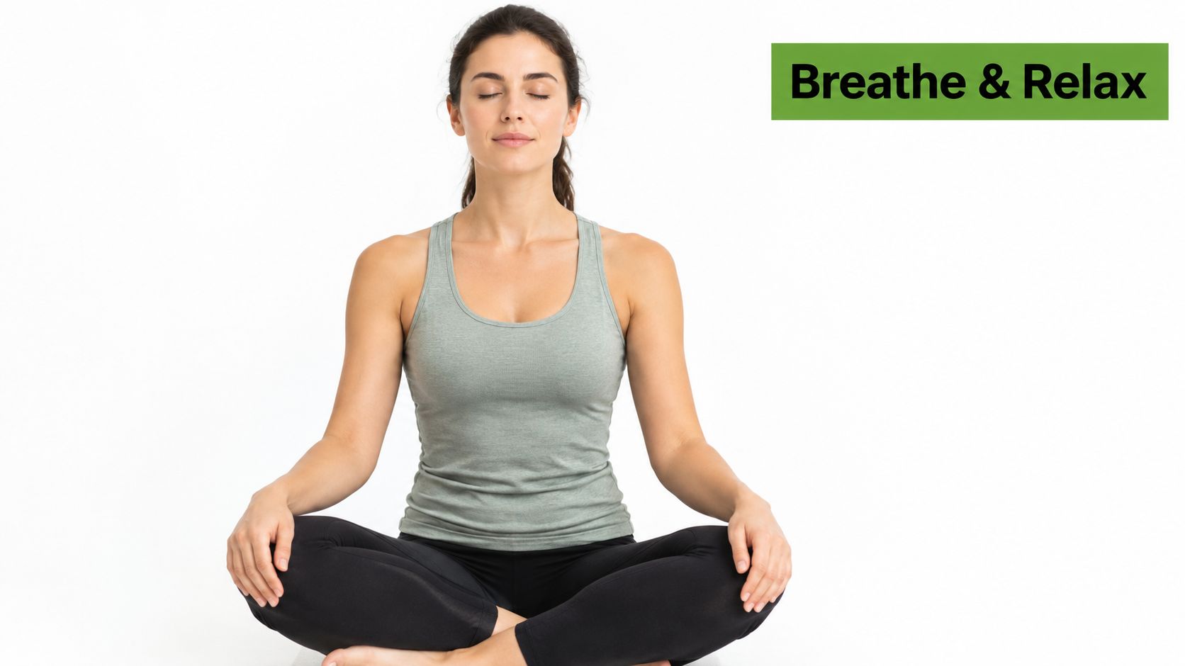 A young woman in workout clothes sitting cross-legged on the floor, meditating with eyes closed to relax.