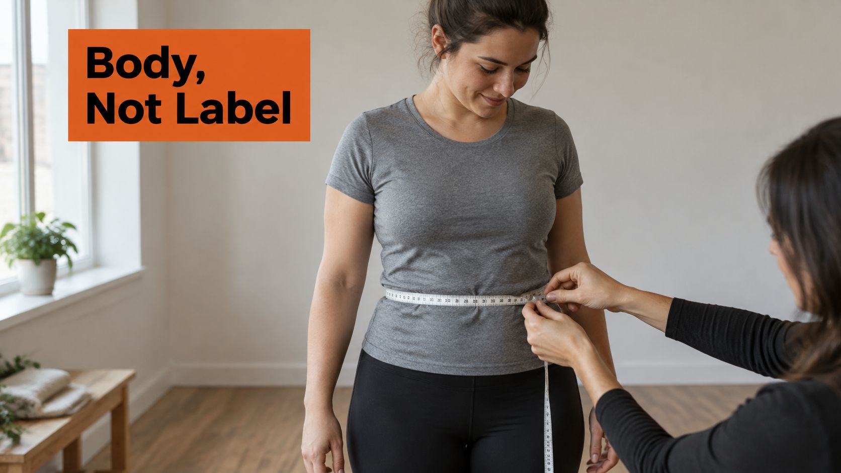 A professional measures the waist of a woman with a tape measure in a bright studio.