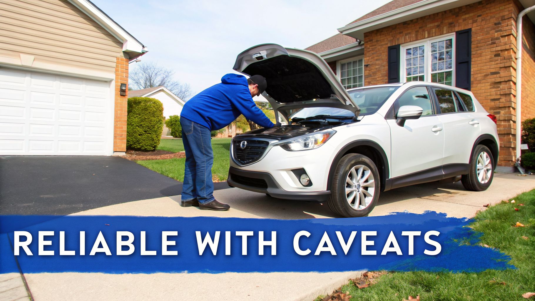 Man in blue hoodie inspecting the engine of a white Mazda CX-5 SUV in a driveway.
