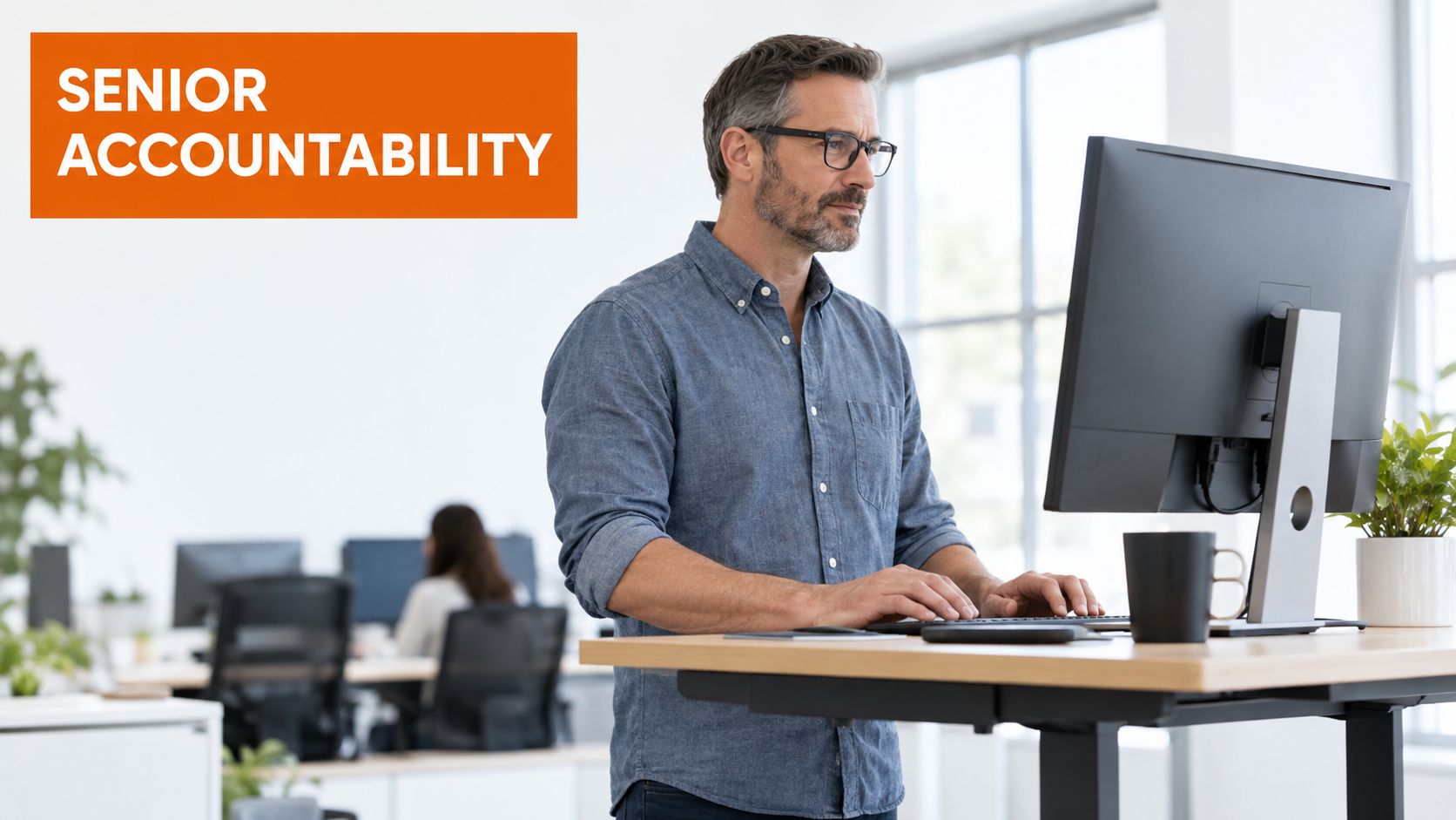 A professional man with glasses working at a standing desk in a bright, modern office environment.