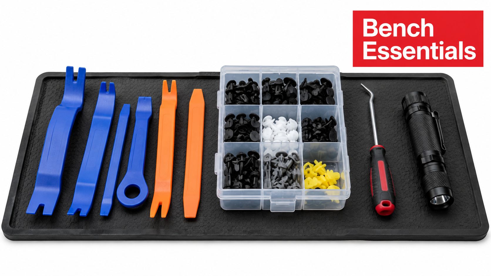 A set of automotive trim removal tools, plastic fasteners, a screwdriver, and a flashlight on a work mat.
