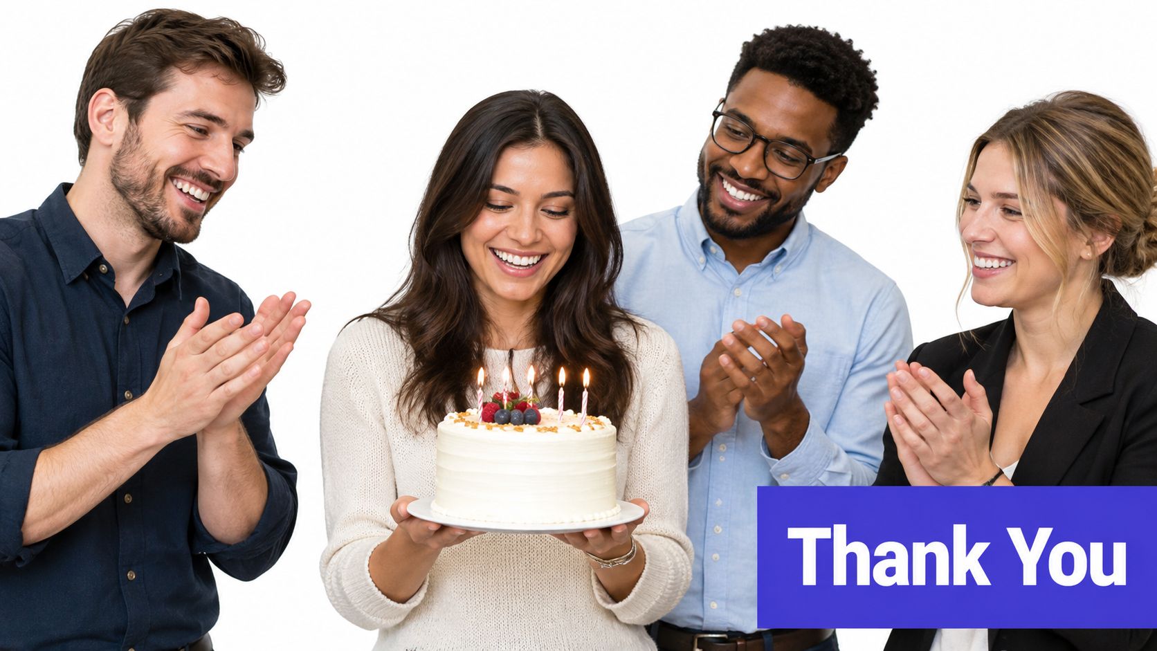 A diverse group of friends smiling and applauding as a woman holds a birthday cake with candles.