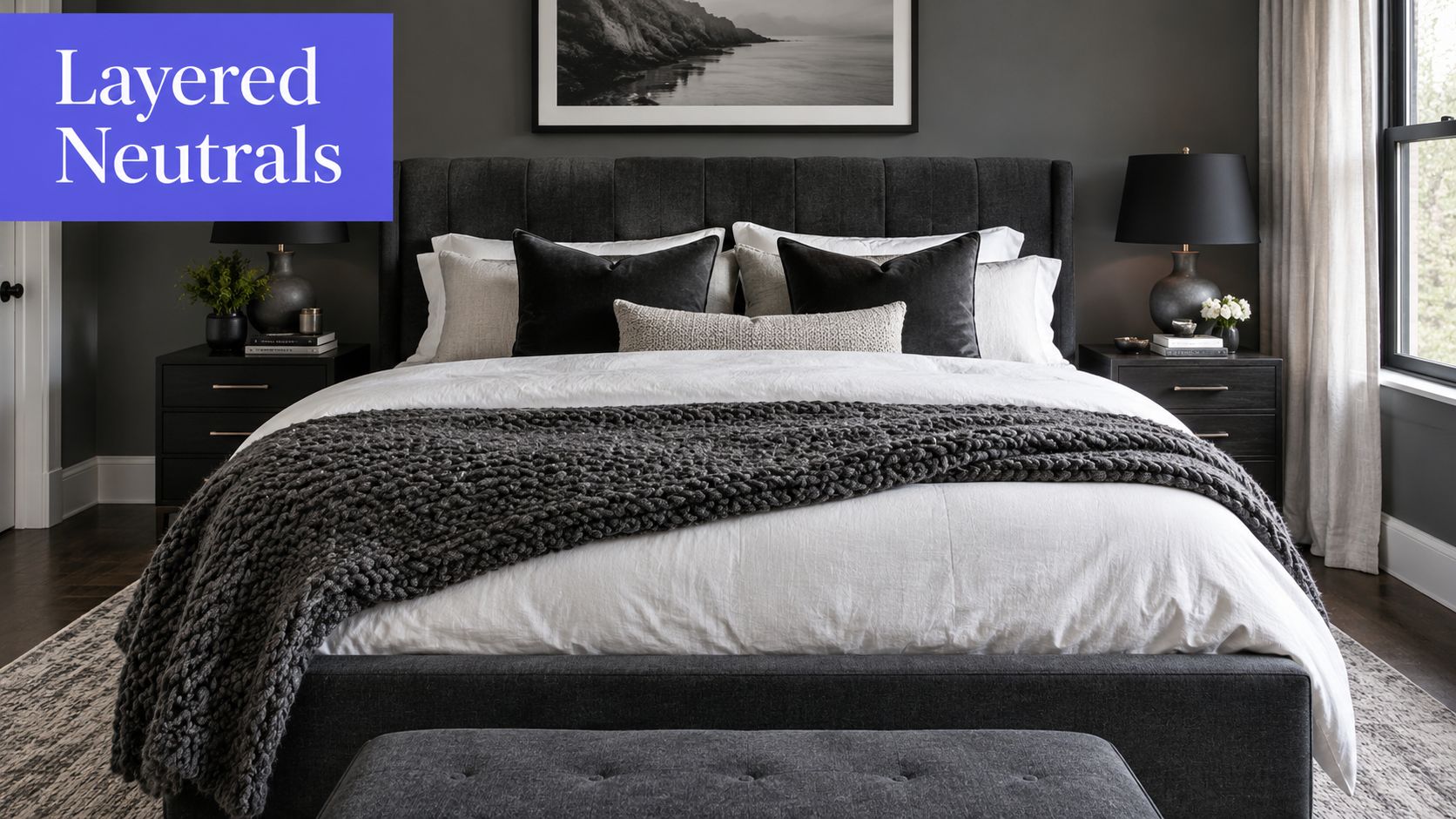 A modern, moody bedroom featuring a dark grey upholstered bed with layered neutral bedding and pillows.