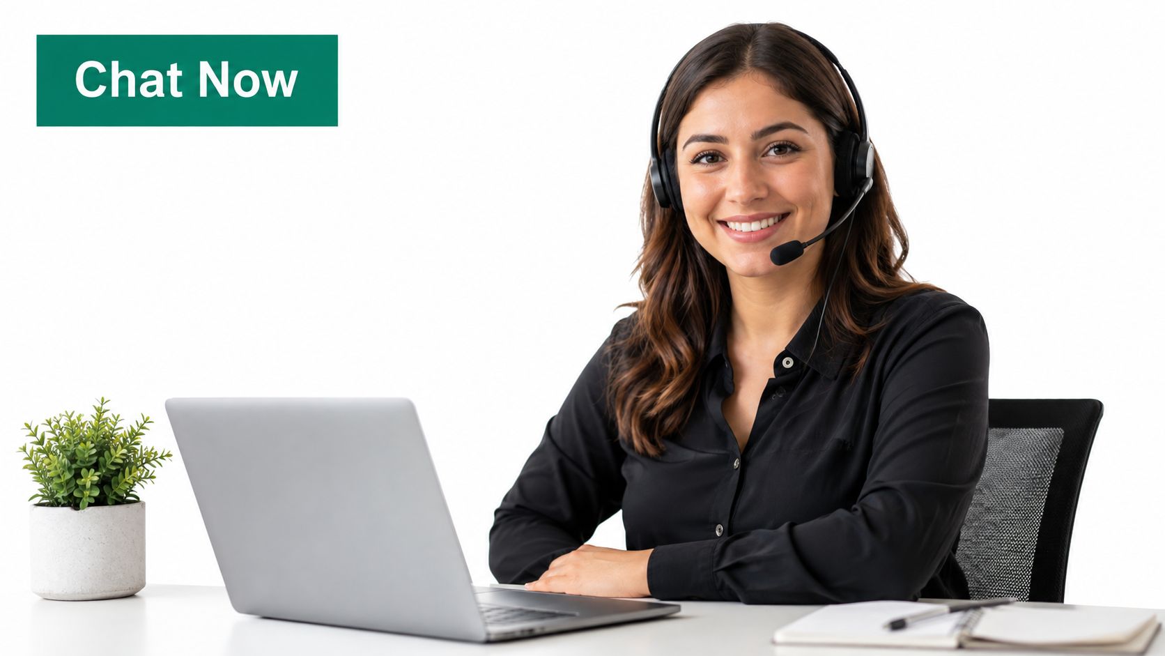 A friendly customer service representative wearing a headset sits at a desk with a laptop and plant.