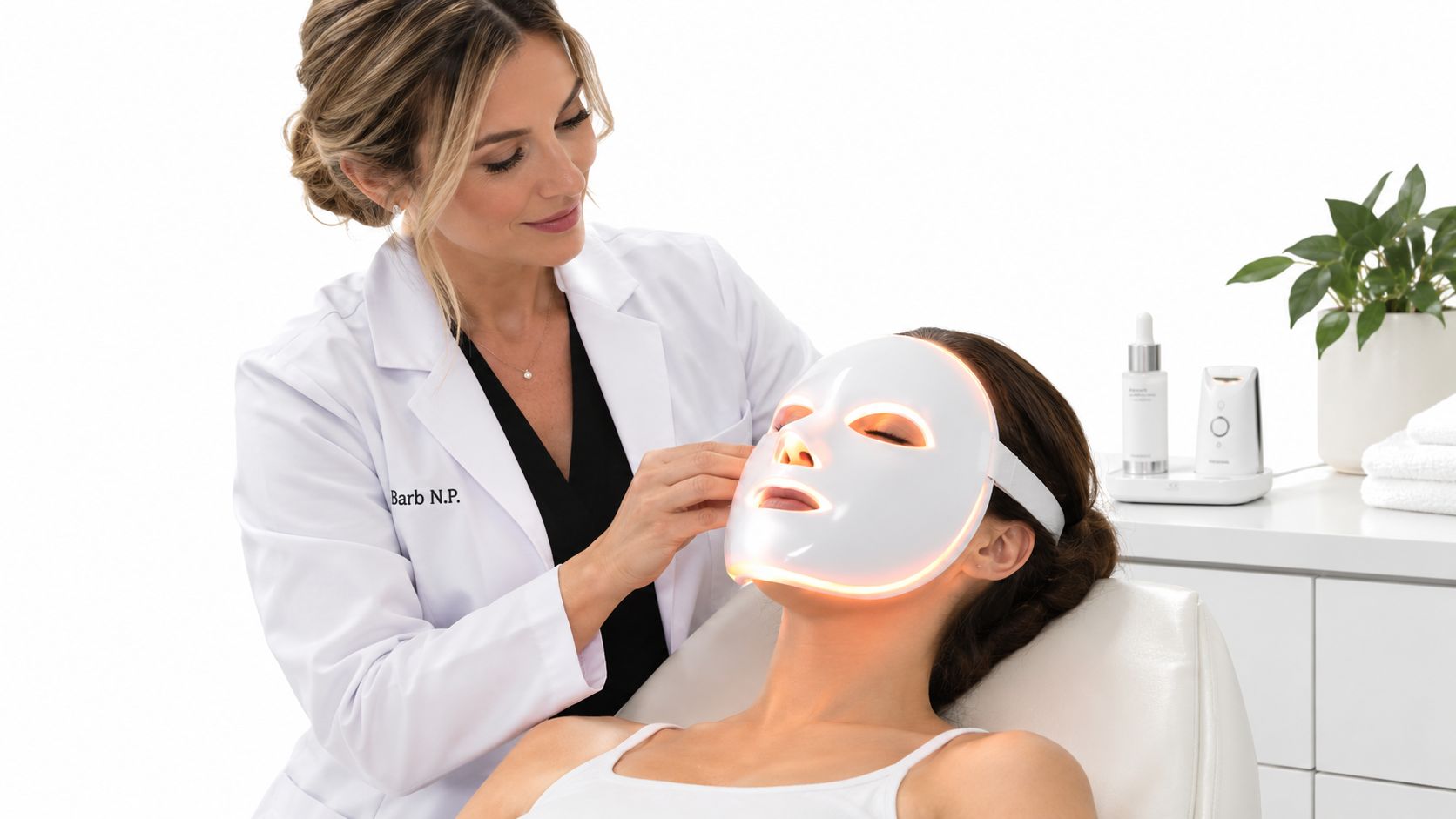 A professional nurse practitioner performing a rejuvenating LED light therapy facial treatment on a female patient.
