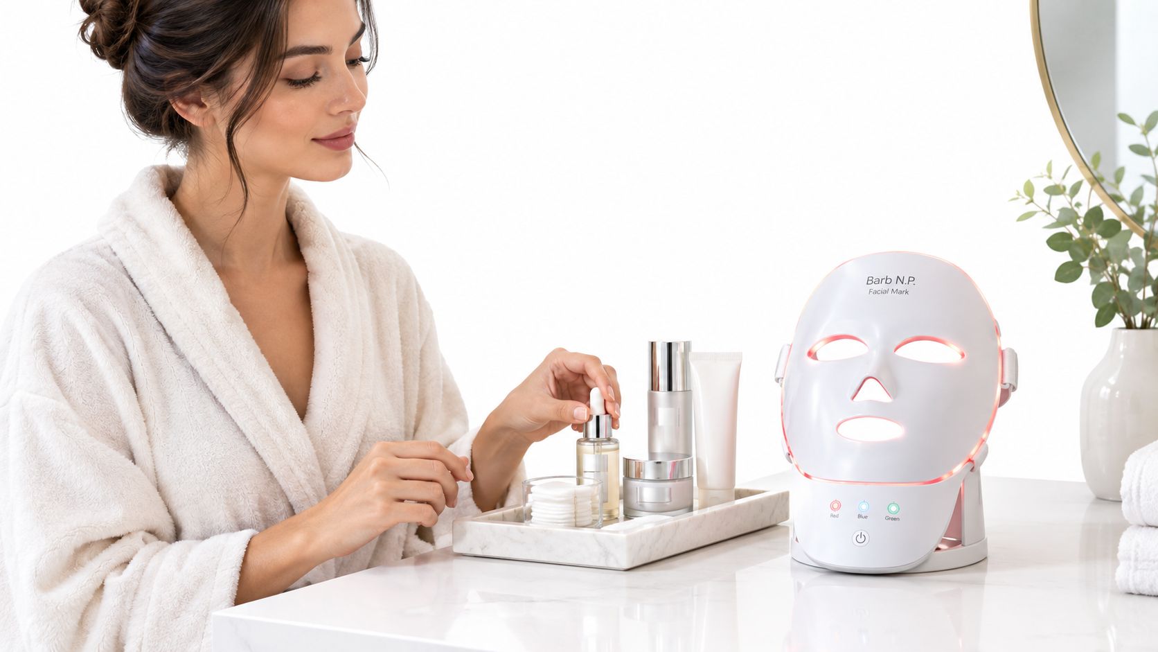 A woman in a white bathrobe using a skincare device next to a tray of cosmetics