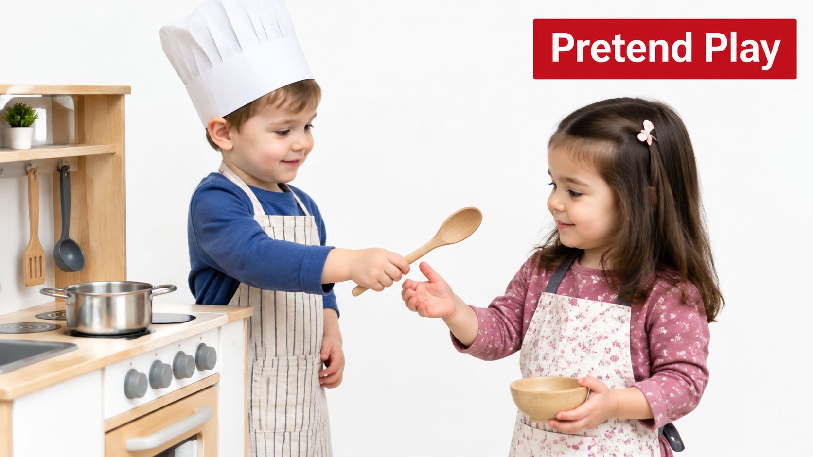 A young boy wearing a chef hat and a girl playing with a toy wooden kitchen