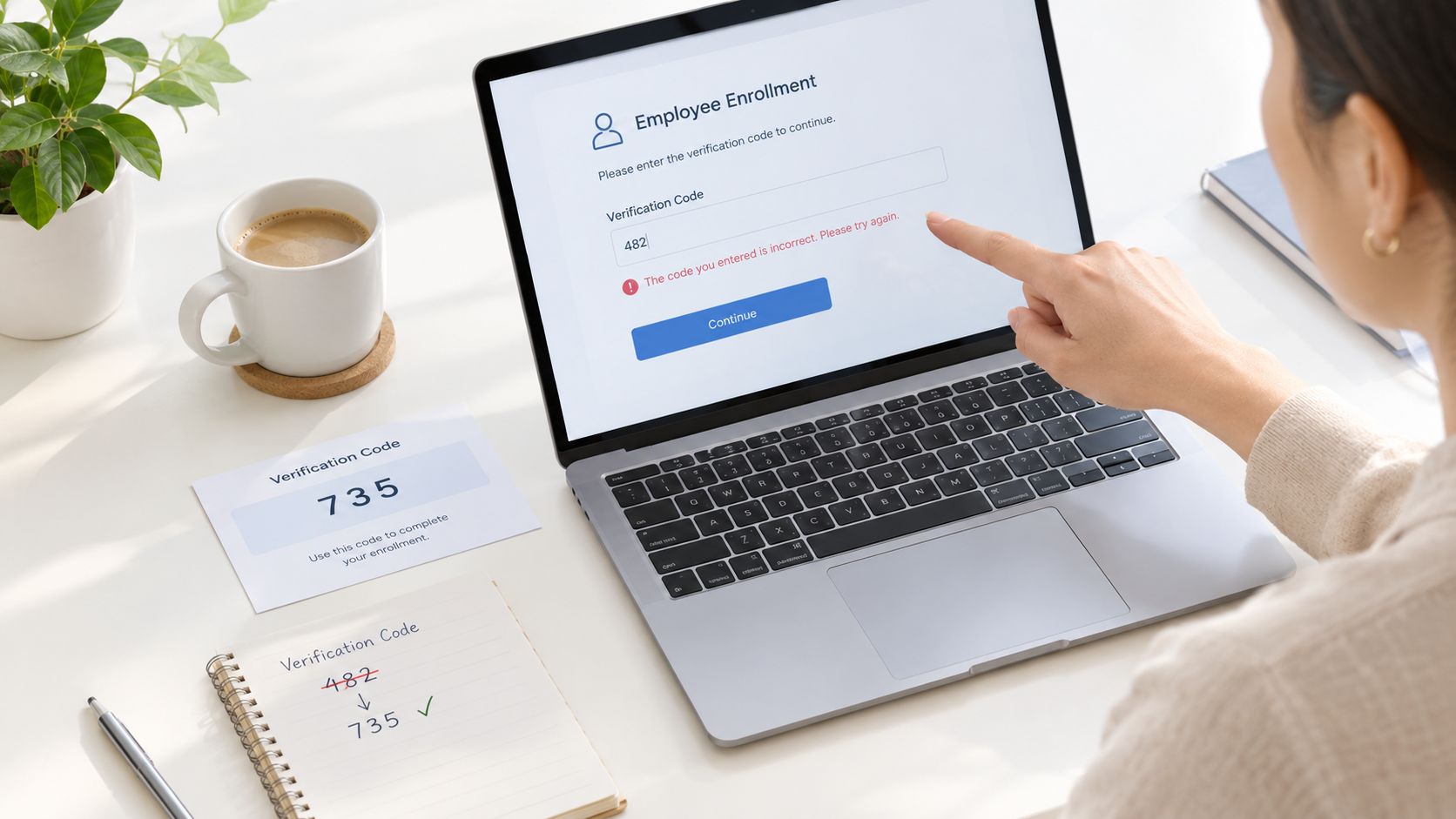 Person entering an employee enrollment verification code on a laptop screen with a coffee cup nearby.