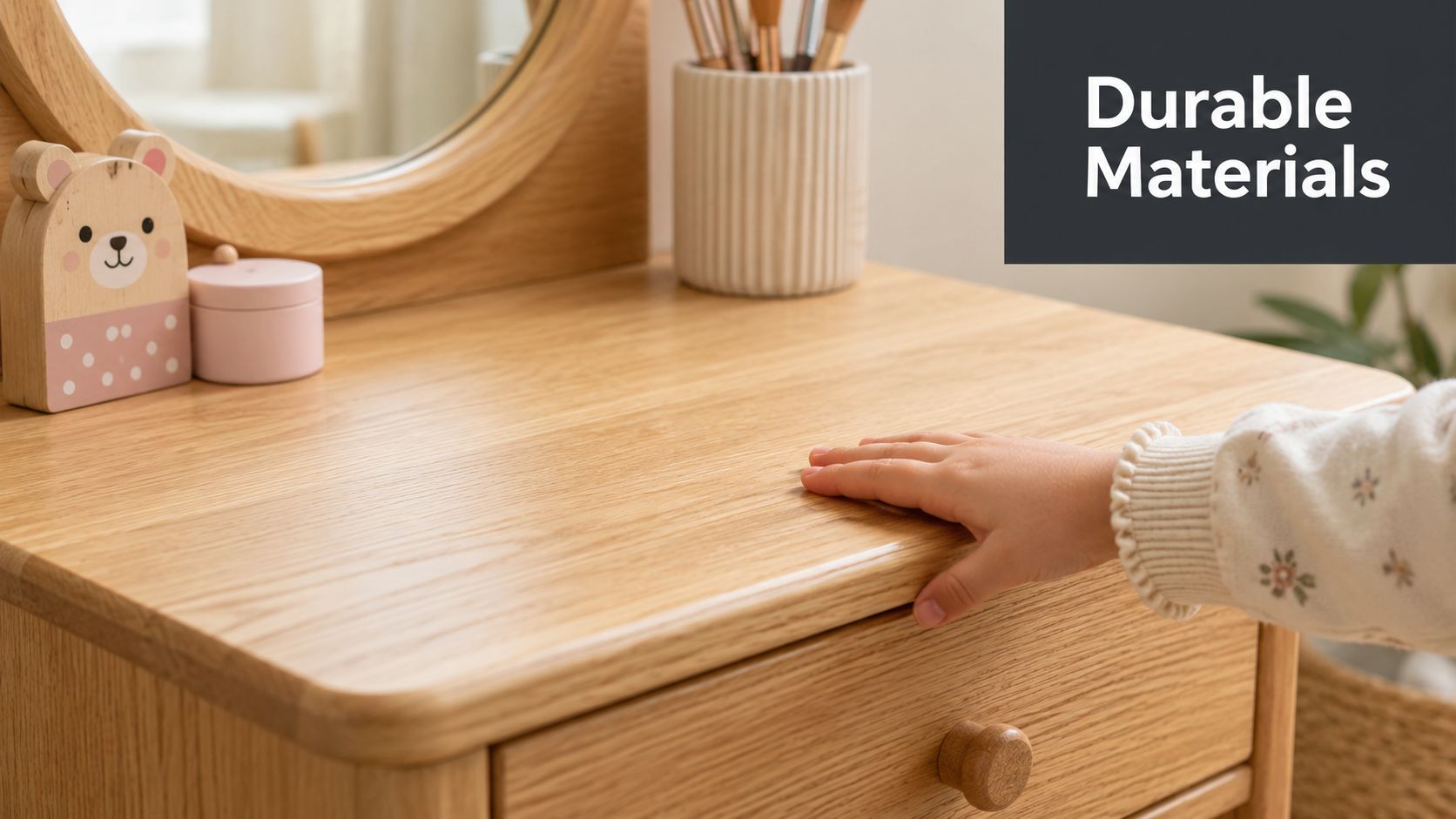A child's hand rests on the smooth wooden surface of a stylish children's dressing table.
