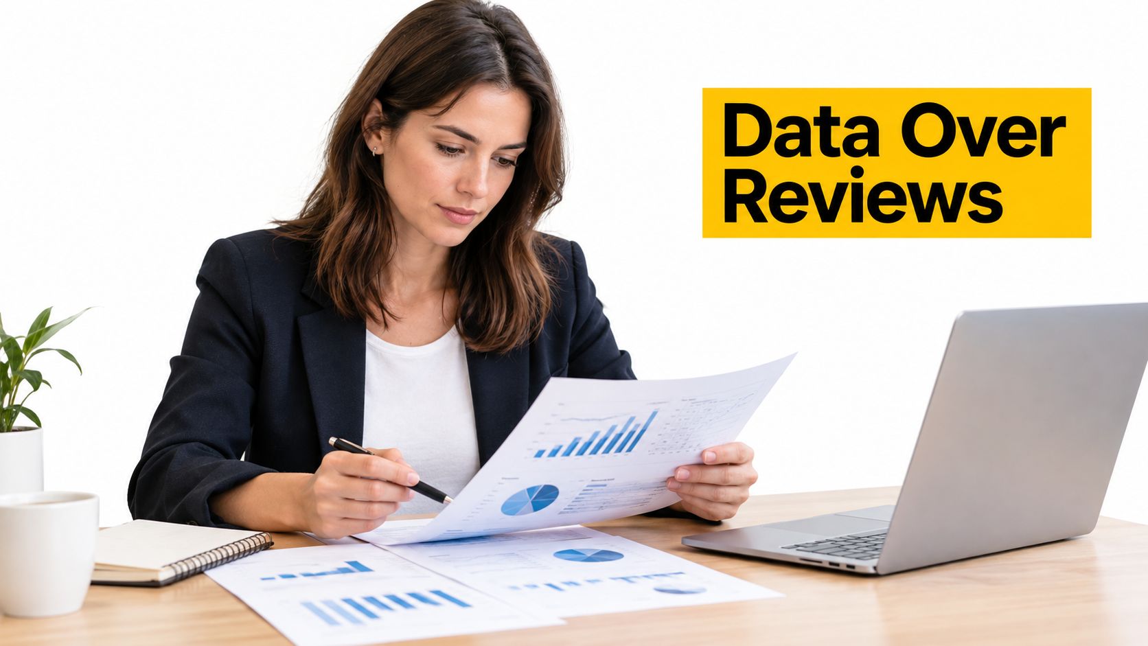 A professional woman in a blazer reviewing business charts and data reports at her office desk.