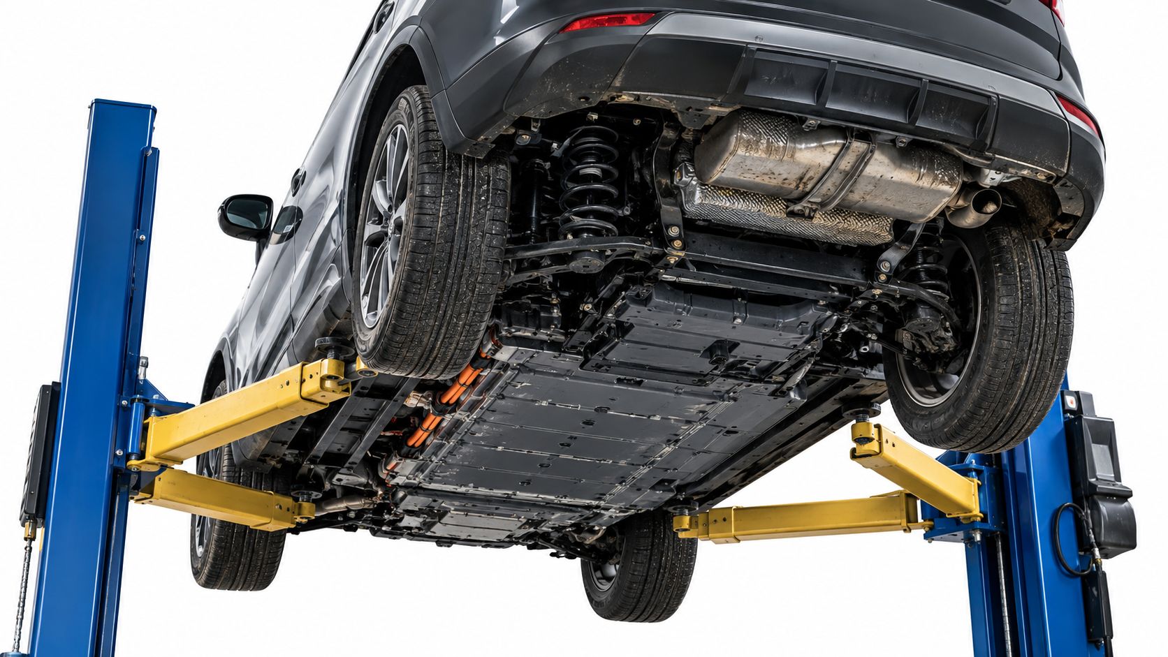 A gray vehicle on a two-post lift showing the undercarriage, battery pack, and suspension components.
