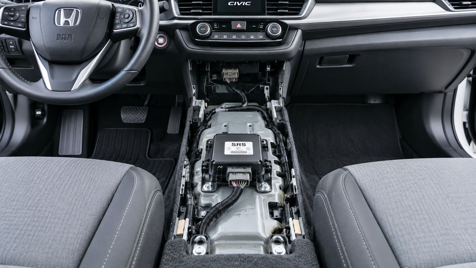 The SRS airbag control module is visible in the center console area of a dismantled Honda Civic interior.