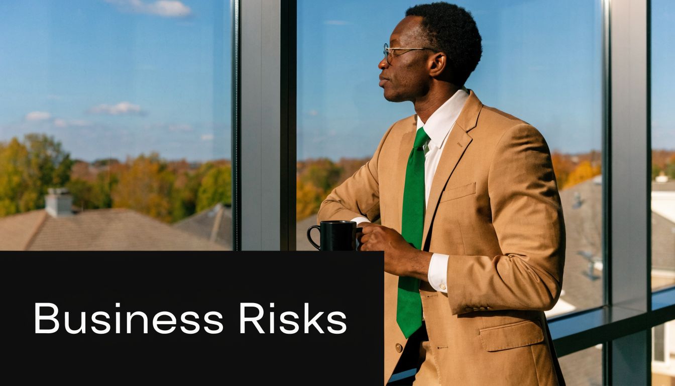 A professional man in a suit looking out the window while holding a coffee mug.