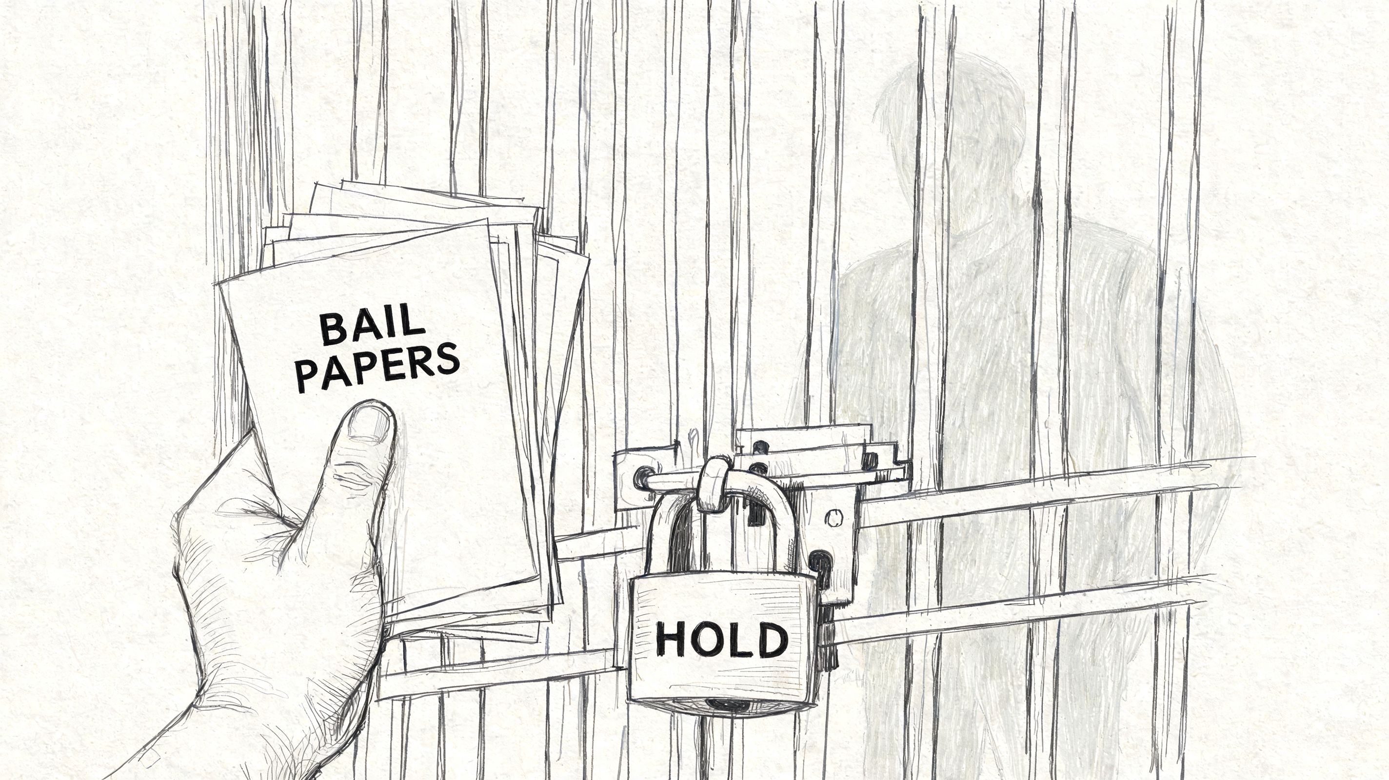 A hand holding bail papers in front of a locked prison cell door labeled with hold.