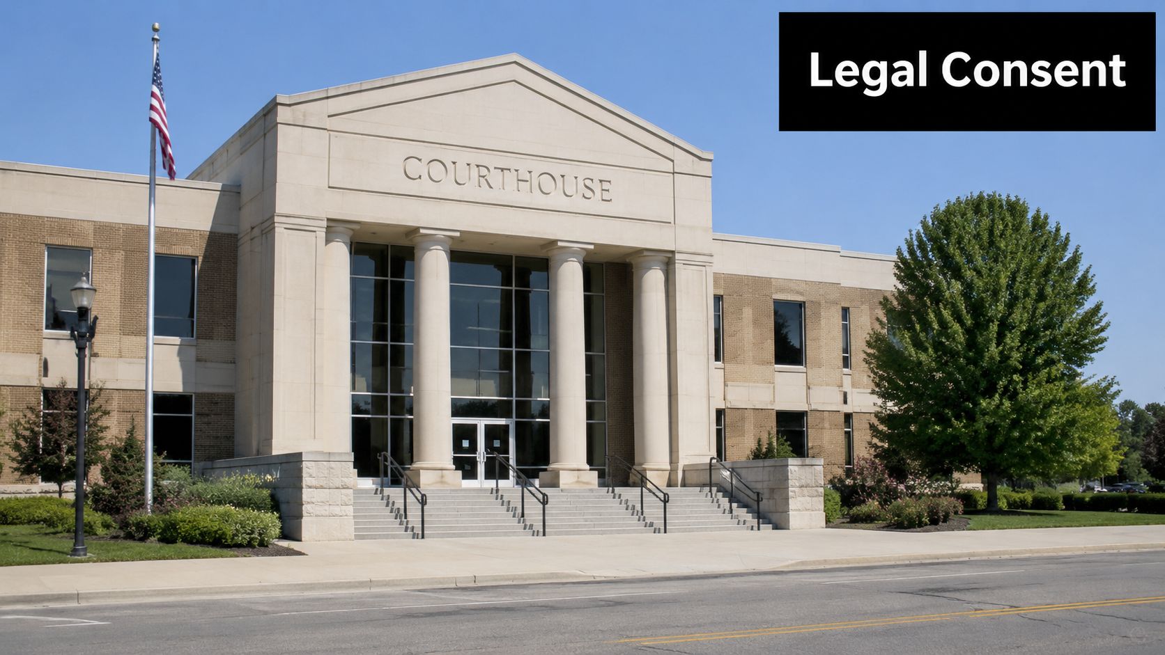 The exterior view of a modern brick and stone courthouse building with large columns and a flag.