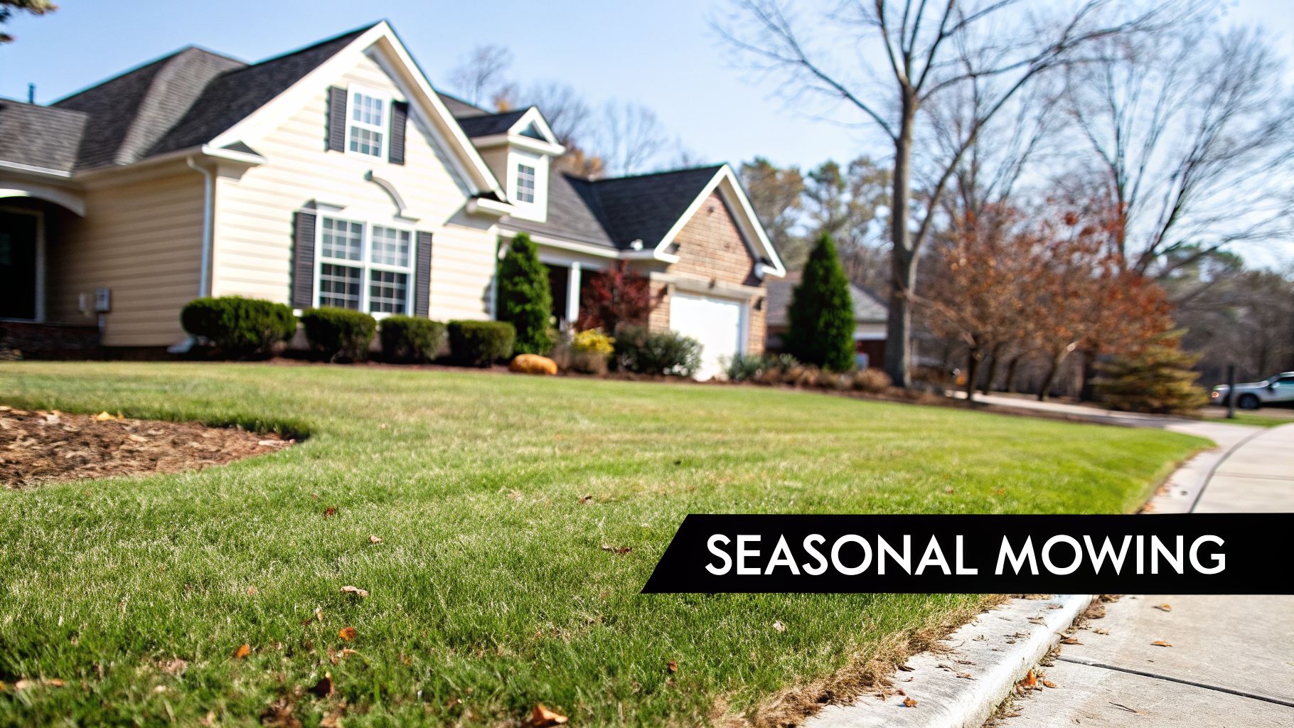 A neat suburban house with a vibrant green lawn and trees, advertising 'SEASONAL MOWING' services.