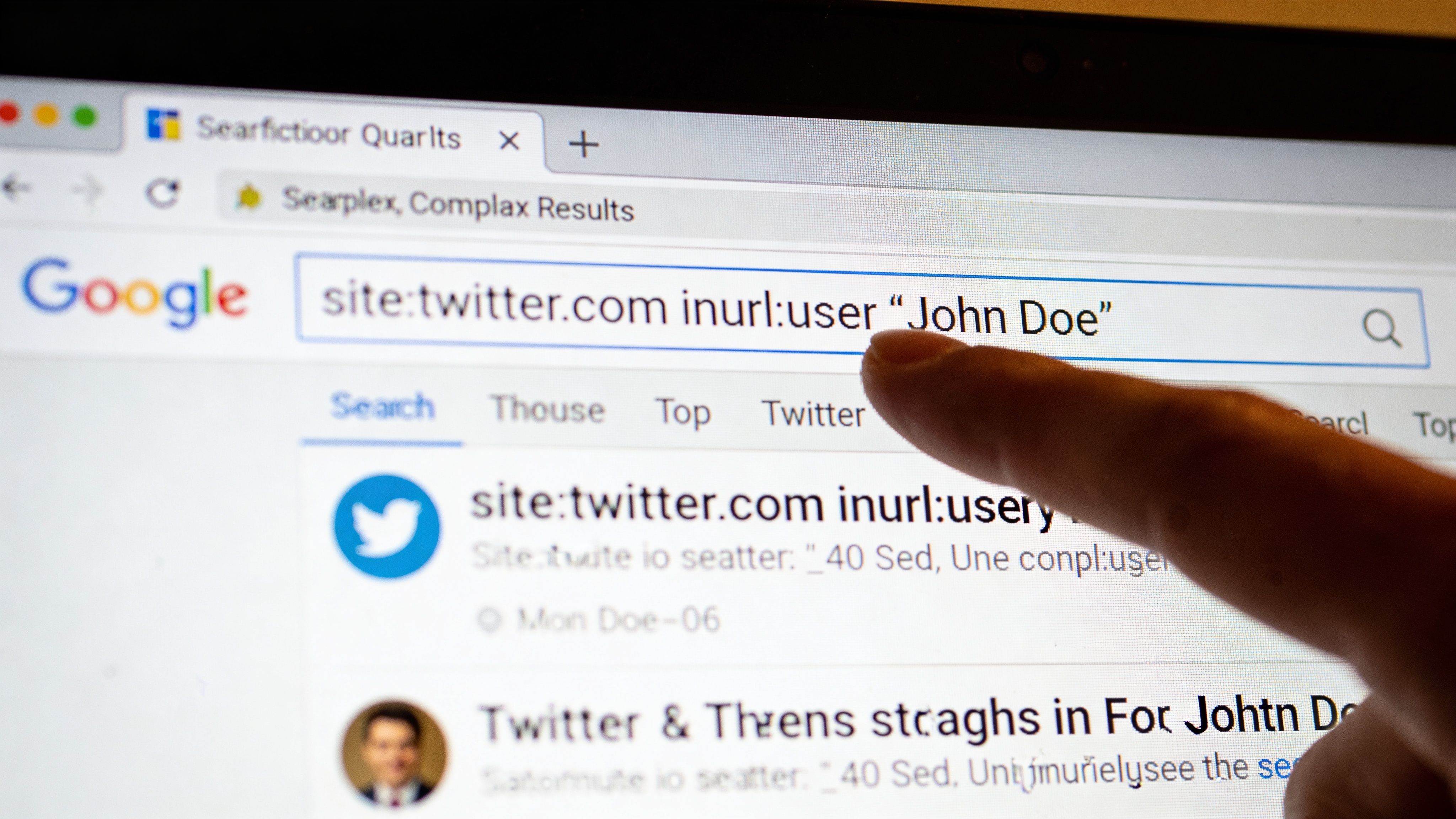 A person using a finger to point at a Google search query on a computer screen monitor.