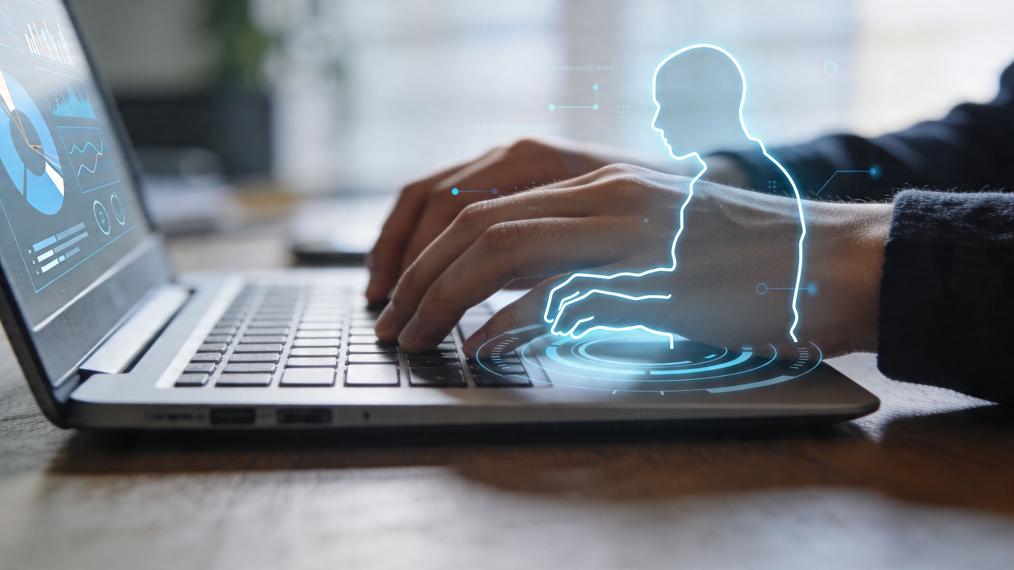 A close-up of a person typing on a laptop with a digital holographic overlay of a human