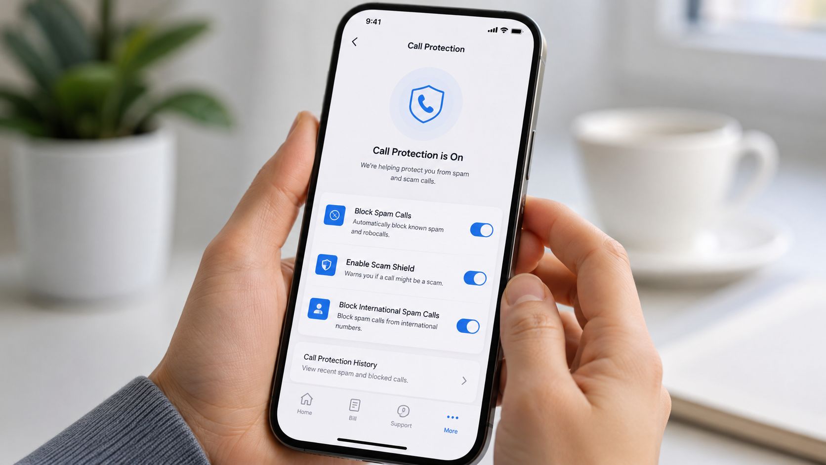 A person holding a smartphone showing an active call protection security app interface to block spam calls.